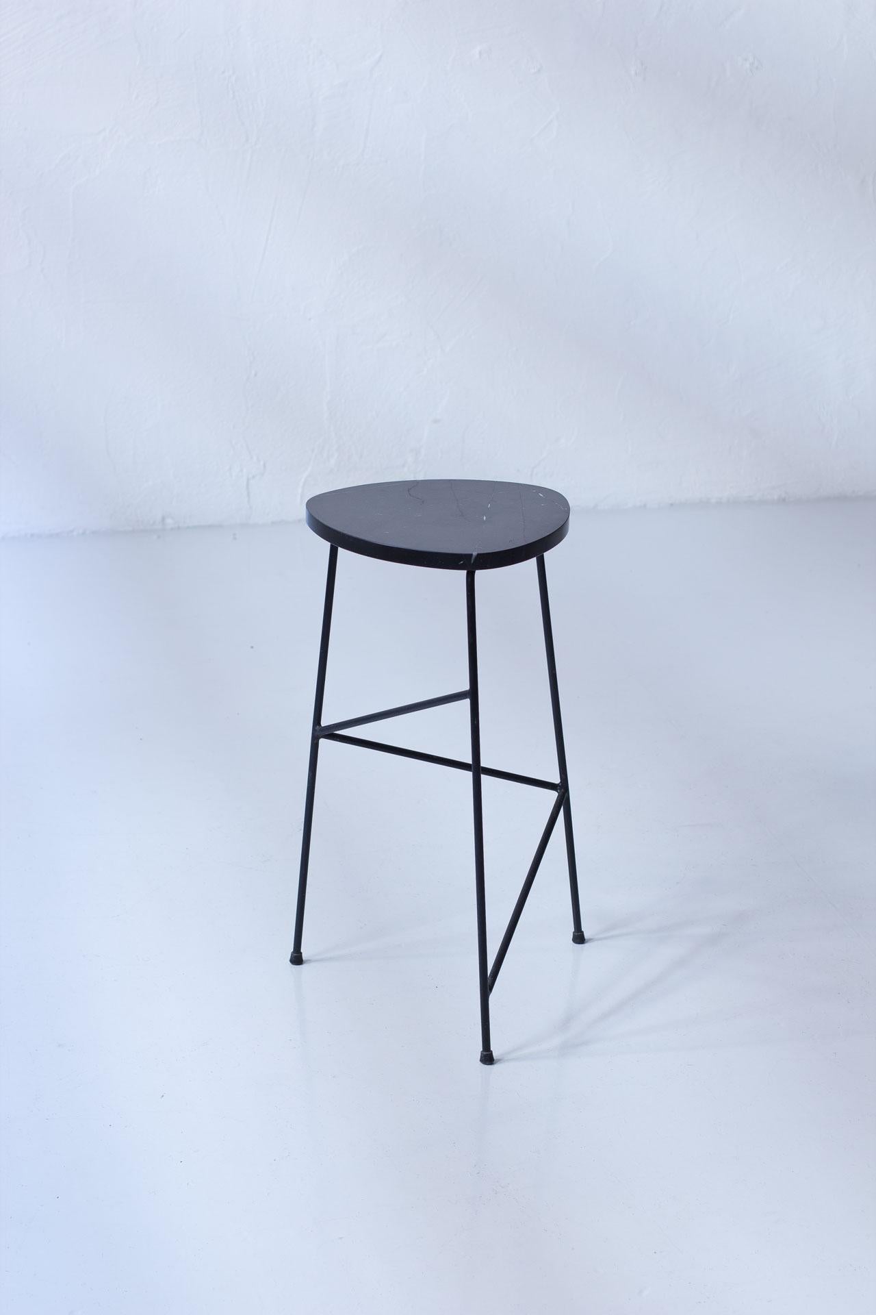 Lovely pedestal designed by Sven Sahlberg, manufactured by 
AB Nybrofabriken, Fröseke in Sweden during the 1950s. The table is made from black Belgian marble slab with black plastic coated metal legs. 

The combination of materials and simple