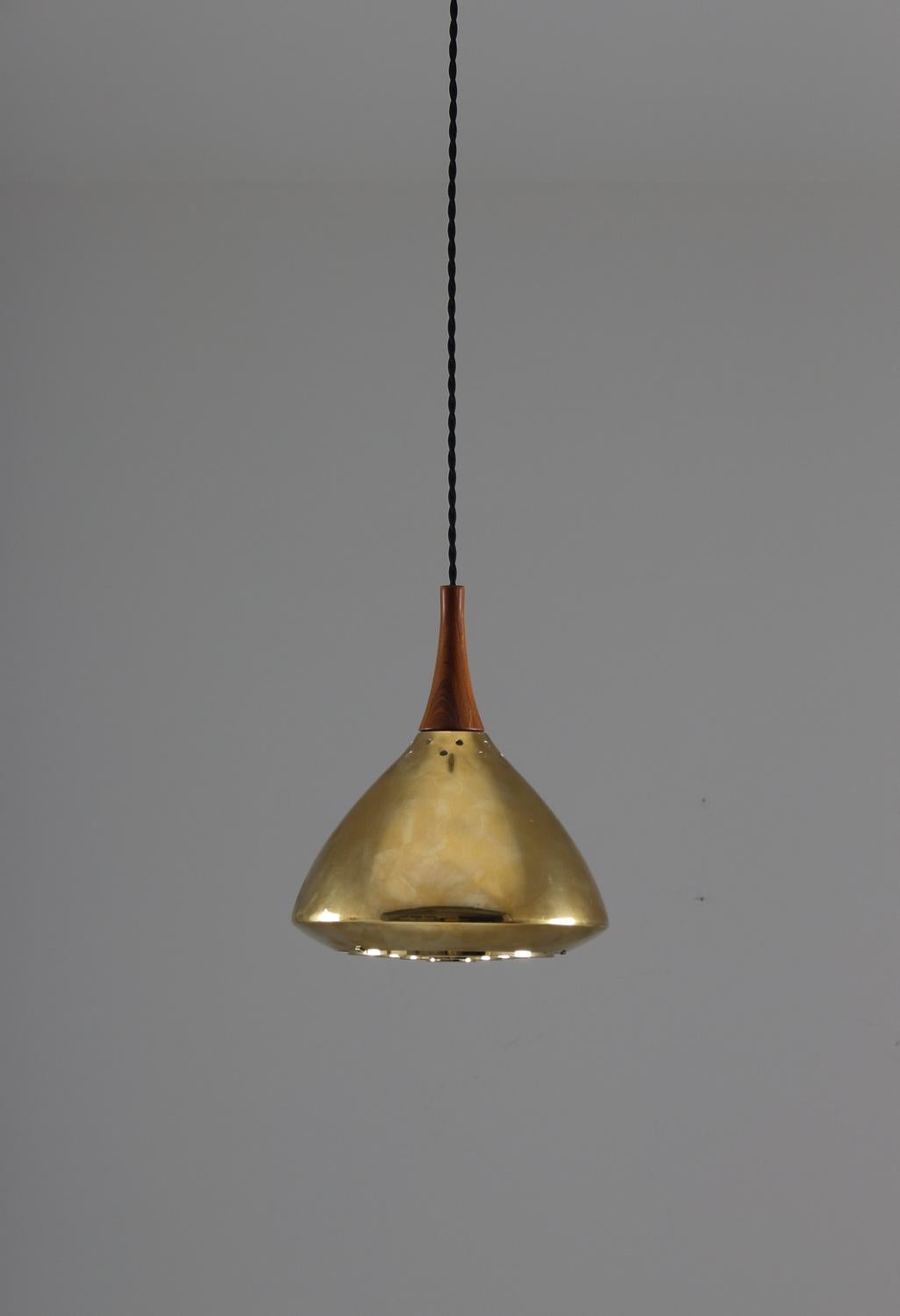 Rare ceiling lamp in brass and rosewood manufactured by Falkenberg, Sweden.
The lamp is made of thick brass and comes with its original brass canopy. The beautiful shape reminds a lot of model 