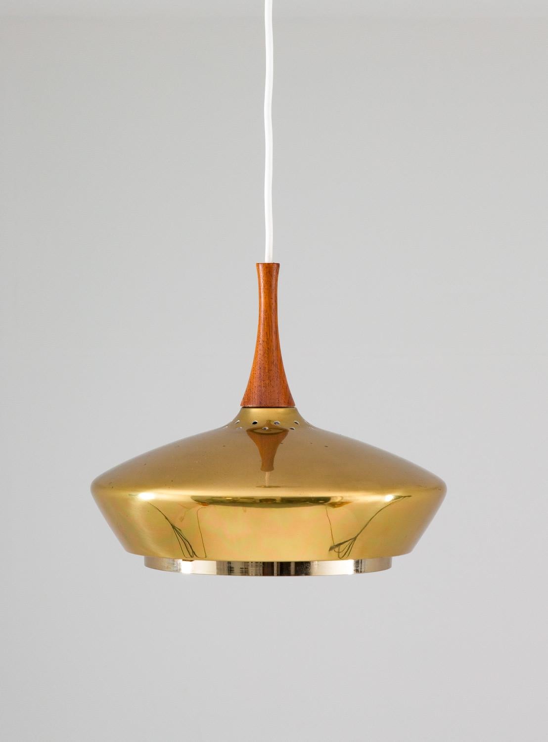 Seltene Deckenlampe aus Messing und Holz, hergestellt von Fagerhult, Schweden.
Die Lampe ist aus dickem Messing gefertigt und wird mit ihrem originalen Messingbaldachin geliefert. Die schöne Form erinnert stark an das Modell 