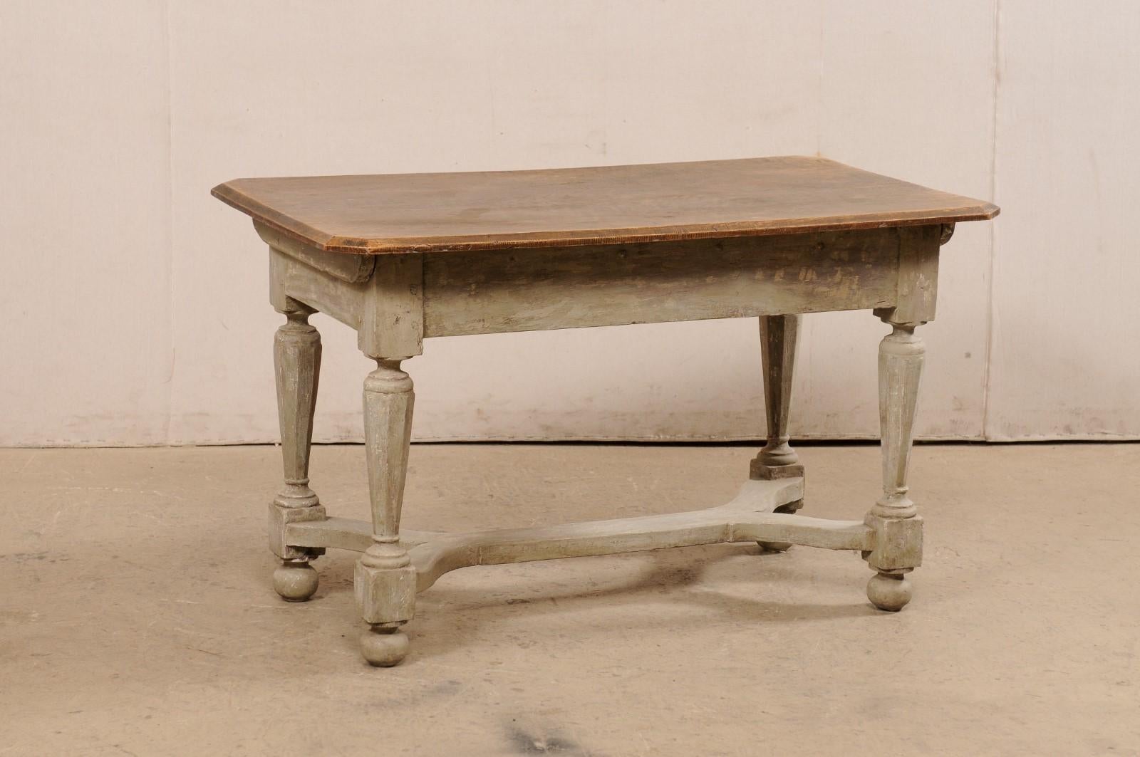 A Swedish period Baroque painted wood occasional table from the turn of the 17th and 18th century. This antique table from Sweden has a rectangular-shaped elm wood top with angular/canted corner edges, atop a thick apron, and presented upon nicely