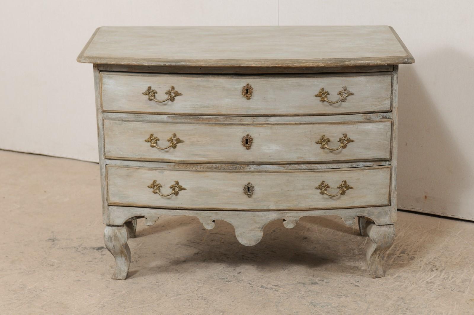 A Swedish period Rococo bow-front painted wood chest of drawers from the mid 18th century. This antique period Rococo chest from Sweden features a bow front top and body, elaborately carved front and side skirts, and is presented upon four robustly
