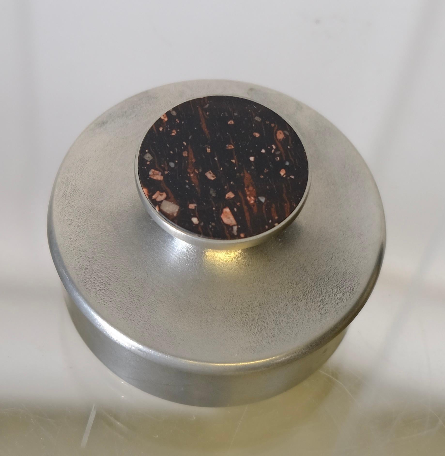 A small pewter box with lid. In the lid a piece of Swedish Porphyry is inlaid. Made 1974 by the company STENLYA.
