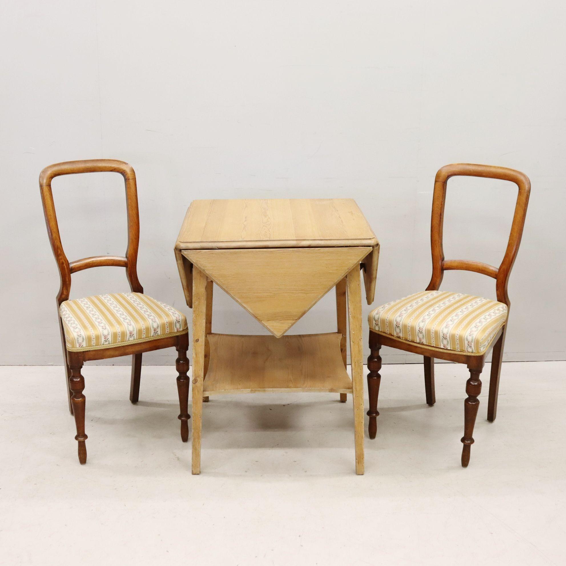 Swedish pine envelope table from (we're guessing) the late 1800s/early 1900s. Four folding flap leaves in triangle shape, can be left down or extended. Pair of chairs from the same era, most likely mahogany with classic turned legs and original silk