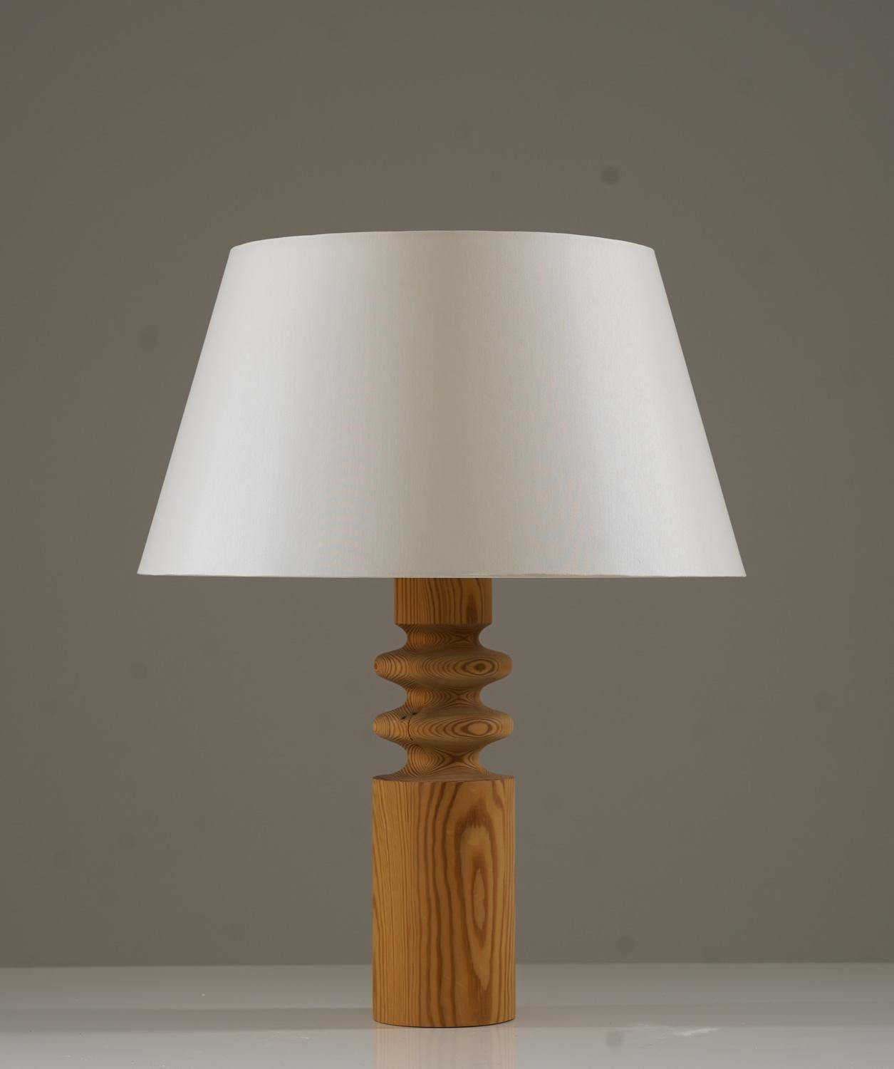Table lamp produced by Luxus, Sweden, 1970s. 
The sculptural wooden base highlights the natural grain of the wood, giving it a warm and organic character. The lamp is fitted with a new shade, complementing its timeless design. 

Condition: Good