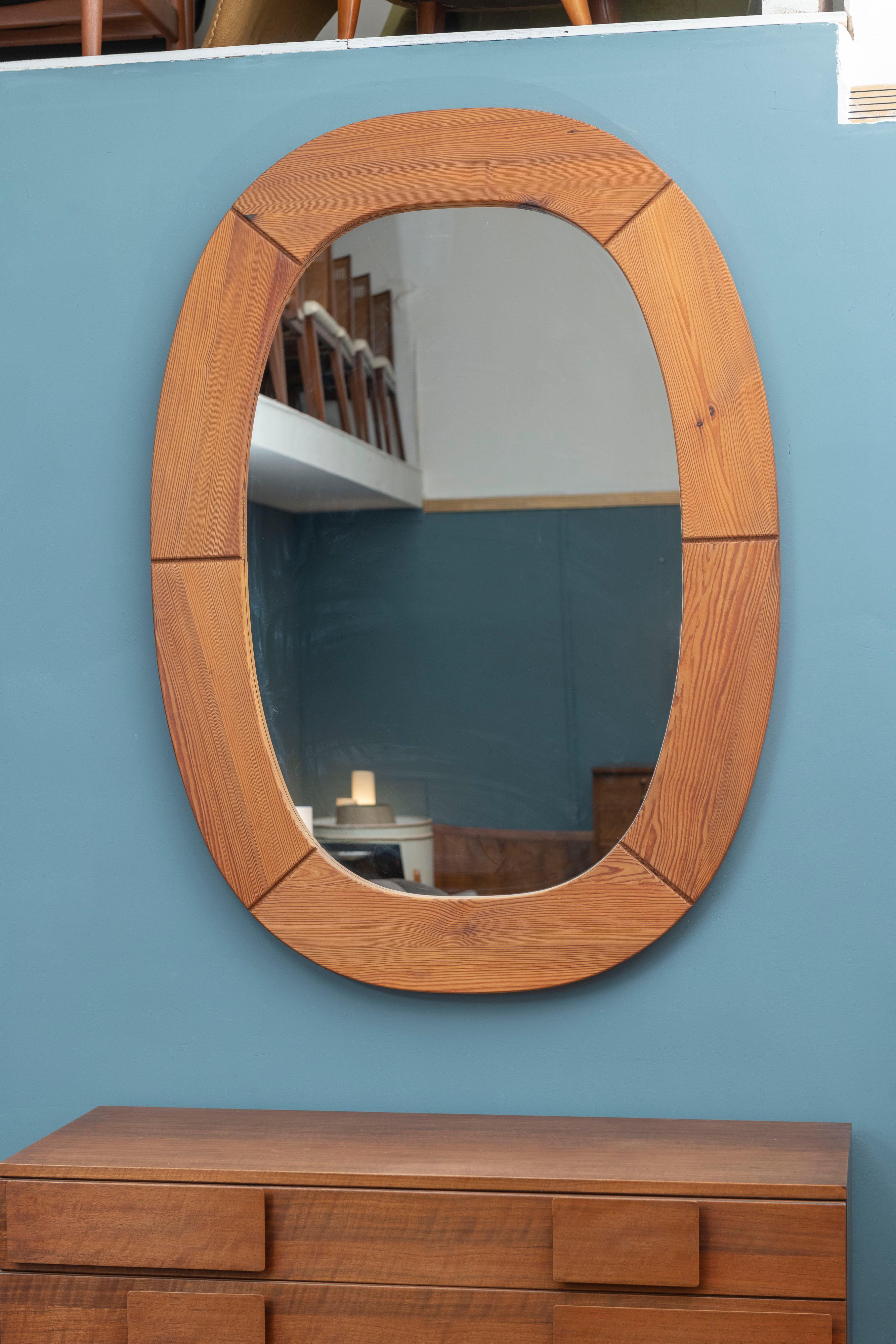 Large Scandinavian Modern solid pine wall mirror in a wonderful oval or cushion shape frame designed by Glasmaster for Markaryd, Sweden. High quality craftsmanship and execution perfect for a minmalist interior, ready to install.
