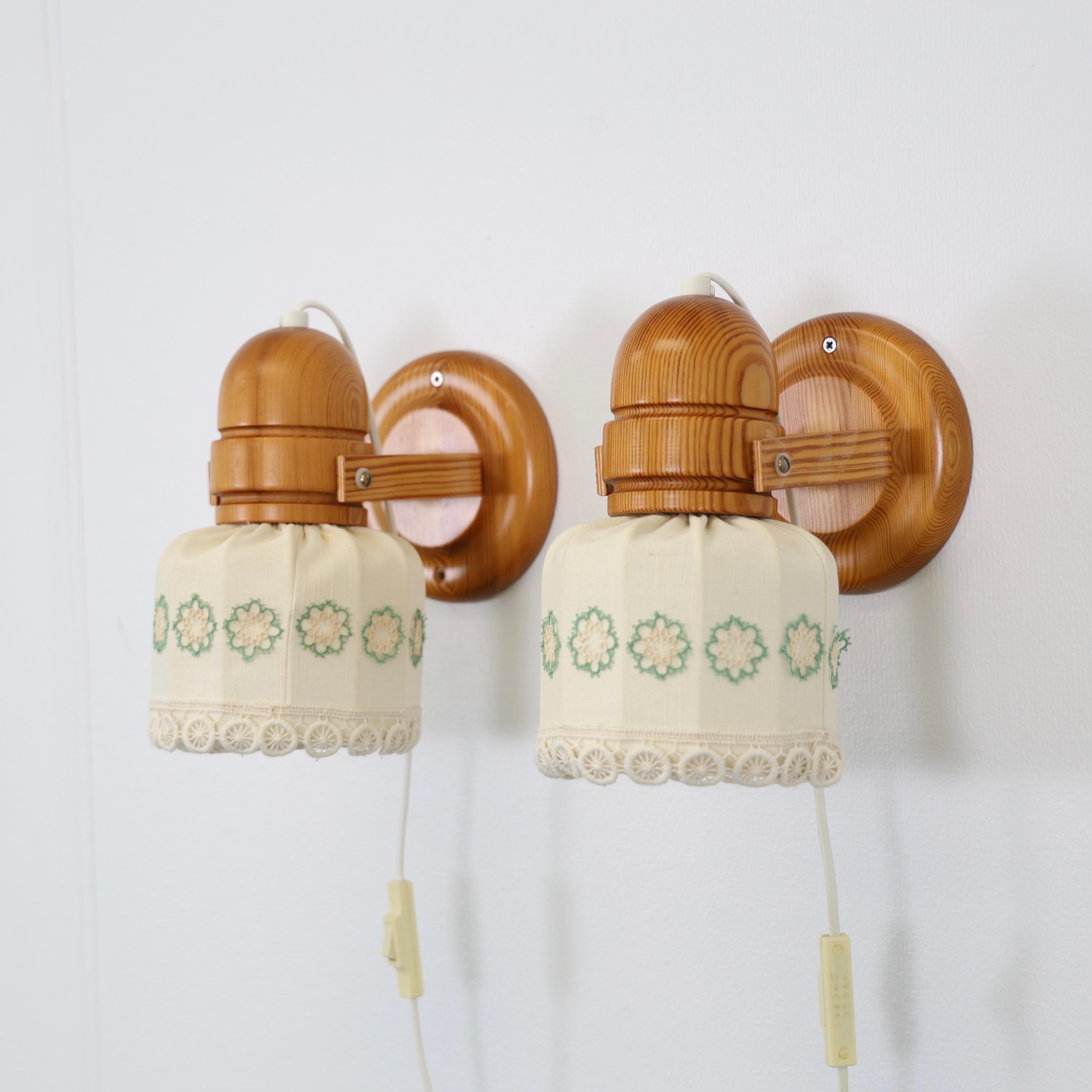 Schwedische moderne Kieferholz-Leuchten mit Schirmen mit Blumenstickereien von Markslöjd um 1980. 

* Set (2) aus Kiefernholz-Wandleuchtern mit cremefarbenen Stoffschirmen mit floralen Stickereien.
* Hersteller: Markslöjd, Schweden
* Stil: 1516
*