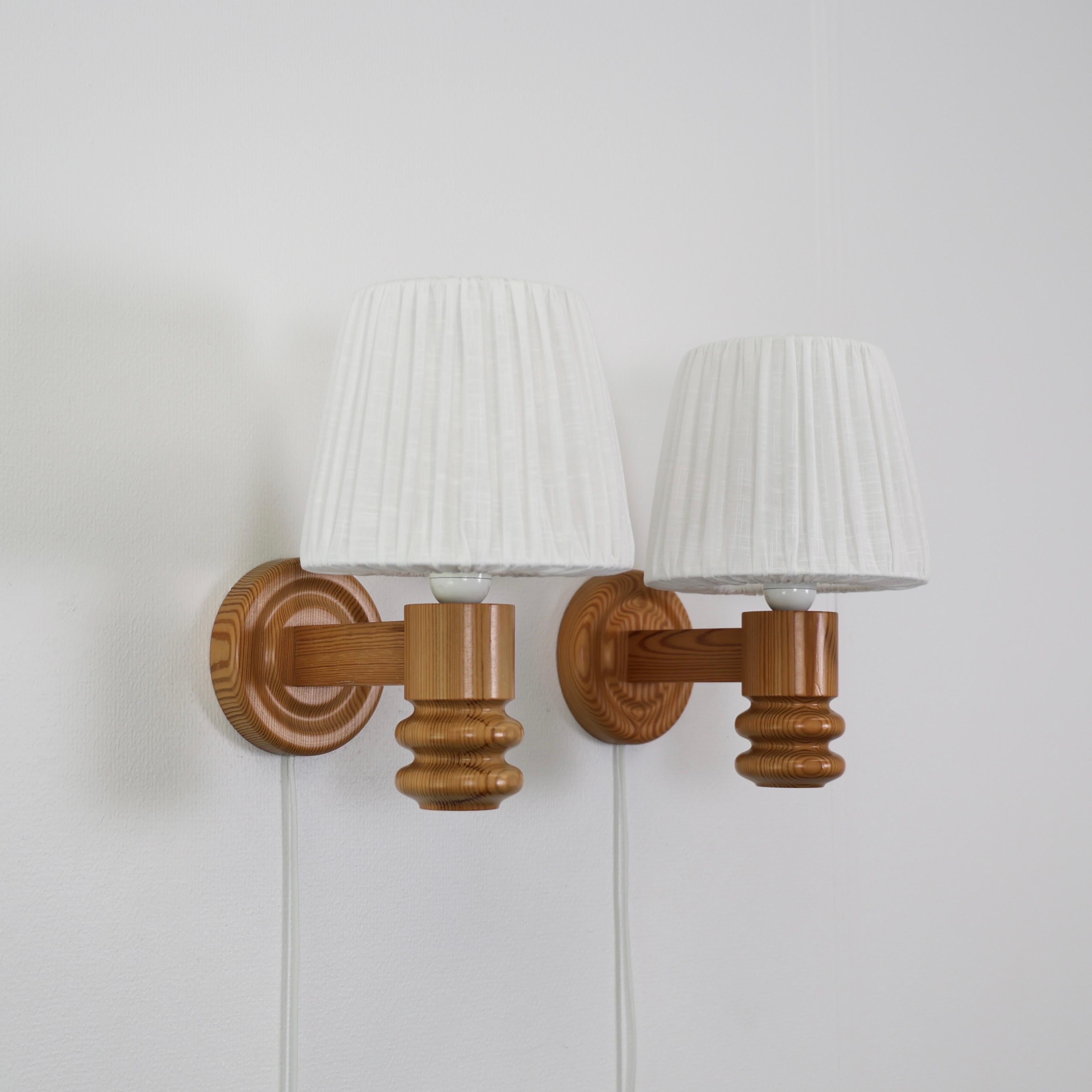 Swedish Modern Pine Wood Sconces made by Solbackens Svarveri in the 1970s. 

* Set (2) of pine wood sconces with white fabric shades.
* Manufacturer: Solbackens Svarveri, Sweden
* Style: 65 A
* Year: circa 1970s
* Condition: Good vintage condition.