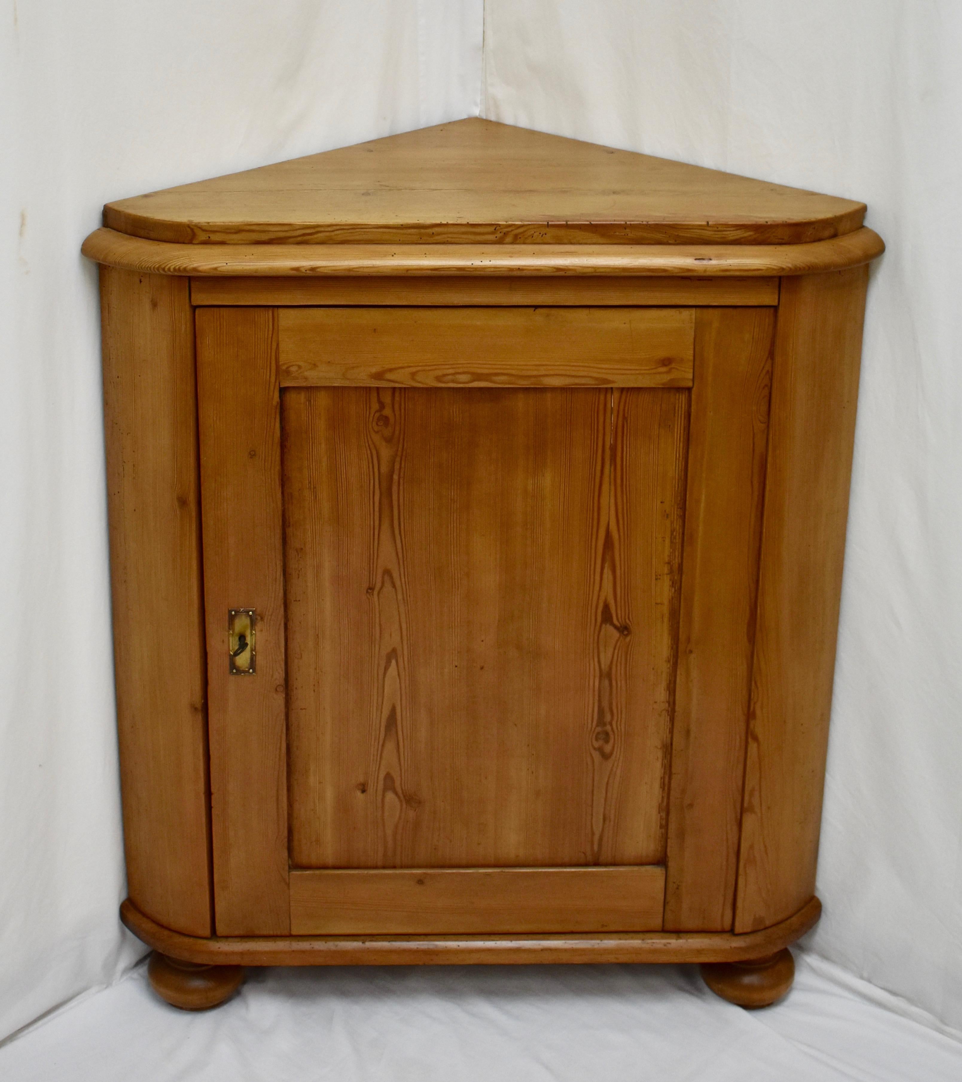 This is a lovely little corner cupboard. Beneath a thick top runs a bold bullnose molding. The flat paneled door below is as plain as they come but the front stiles are gently curved, and the door edge nicely chamfered for a good fit, adding an