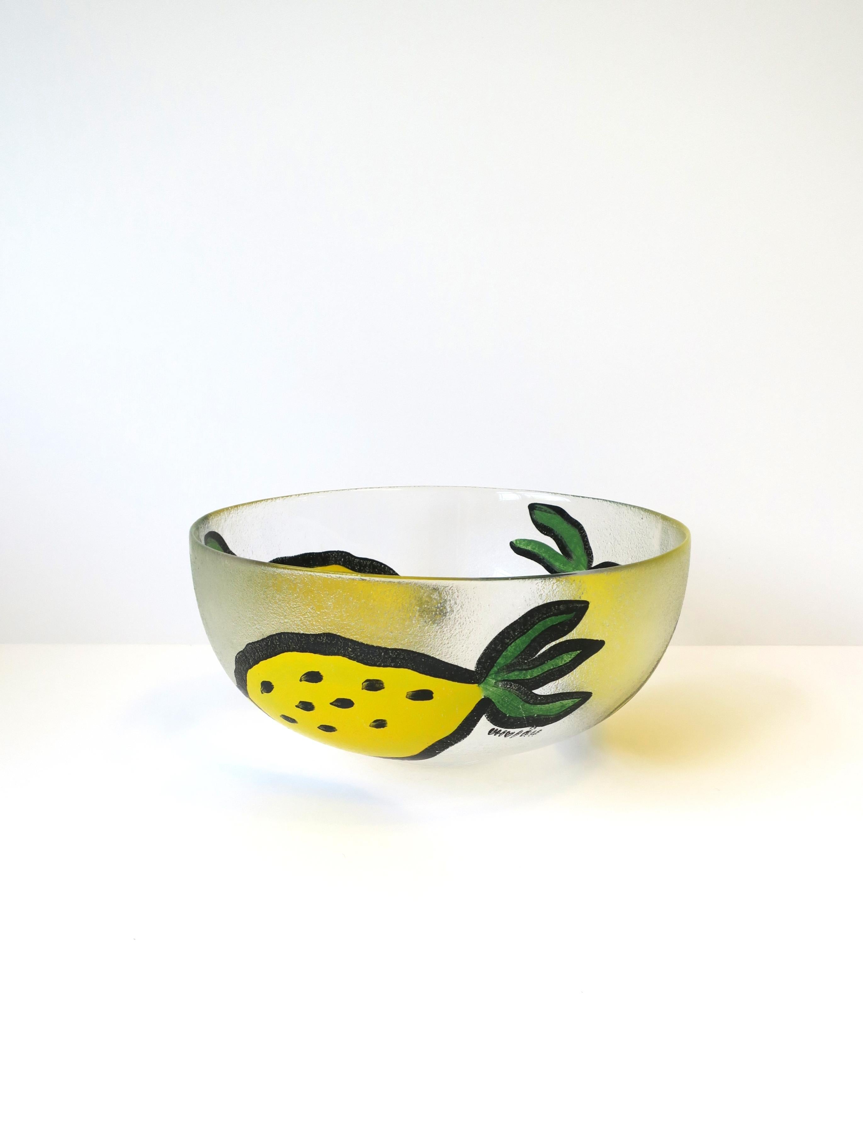 A beautiful Postmodern Swedish art glass centerpiece bowl by artist and designer Ulrica Hydman-Vallien, circa 1990s, for Kosta Boda, Sweden. Centerpiece bowl has three large hand-painted lemons on textured exterior glass surface, with artists