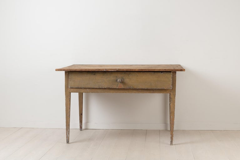 Primitive neoclassical table in Folk Art. The table is provincial and made from painted pine. It has one single large drawer and straight legs without decorations. The table is in untouched original condition with original distressed paint. The knob
