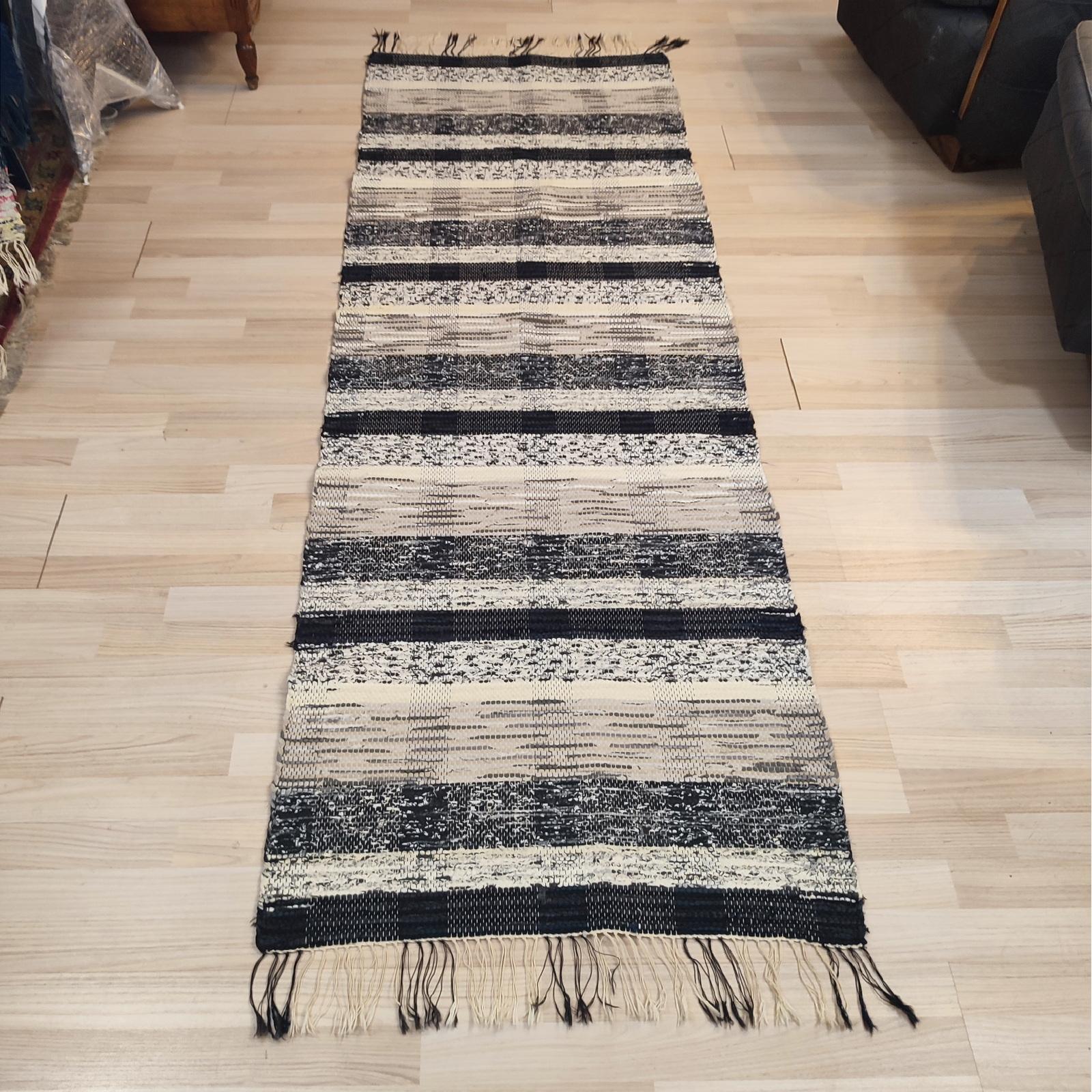Dieser schwedische Flickenteppich aus der Mitte des 20. Jahrhunderts zeichnet sich durch ein geometrisches Streifendesign in gedämpften Ecru-, Weiß-, Grau- und Schwarztönen aus. 
Schwarze und ecrufarbene Fransen in perfektem Zustand.
80x240 cm
In