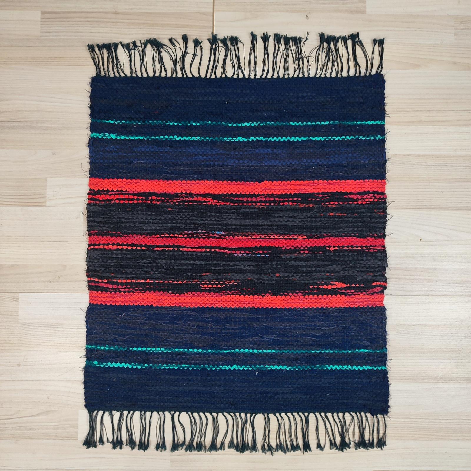Tappeto di pezza svedese moderno della metà del XX secolo, presenta un disegno a righe geometriche in rosso, blu scuro e verde acqua su sfondo nero, rifinito con frange nere. 
Frange nere ed ecru in perfette condizioni.
68x84 cm
In ottime condizioni