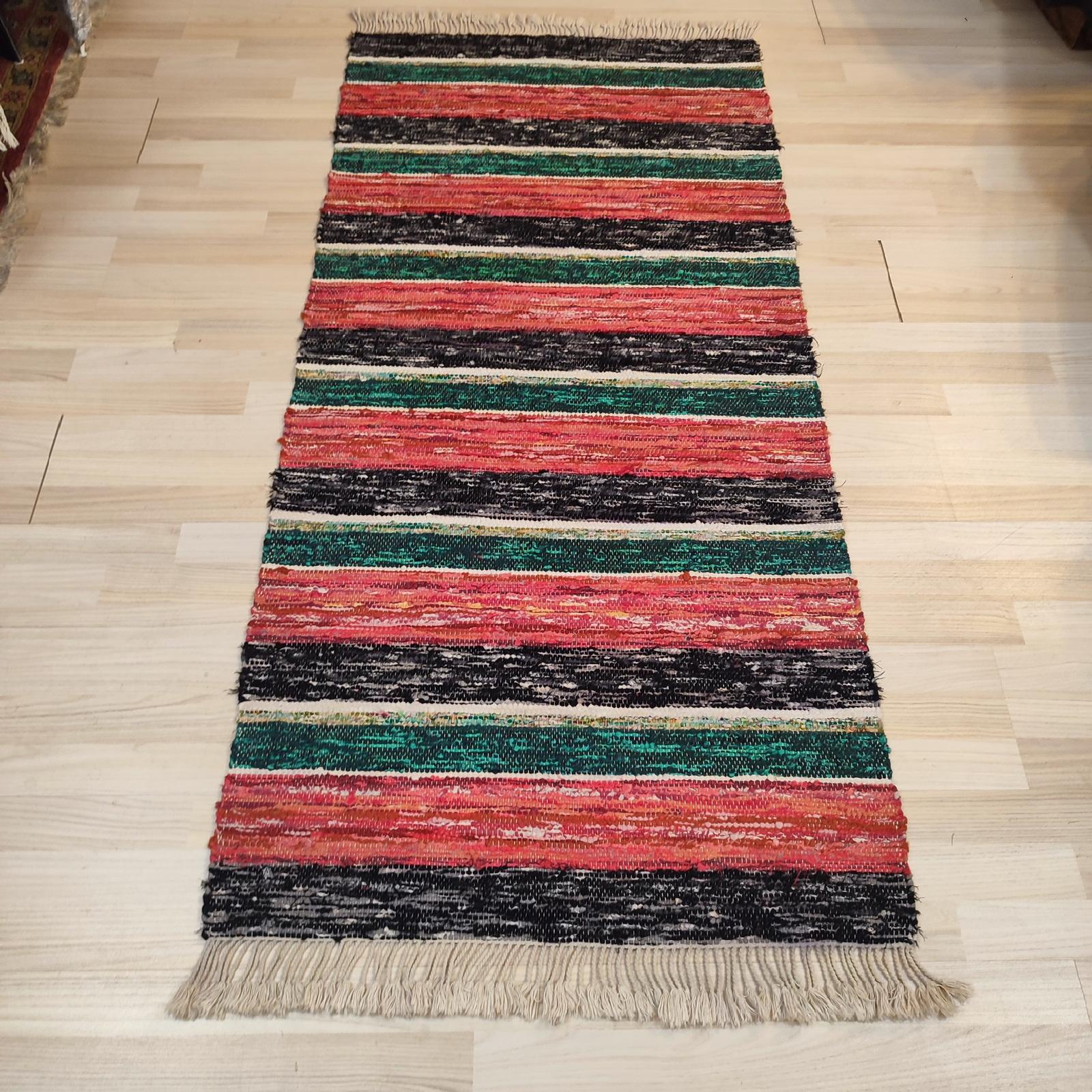 A mid-20th-century Swedish rag rug, it features a geometric stripe design in red, green, grey, and black tones. 
Ecru braided fringes in perfect condition.
80x182 cm
In excellent used condition.