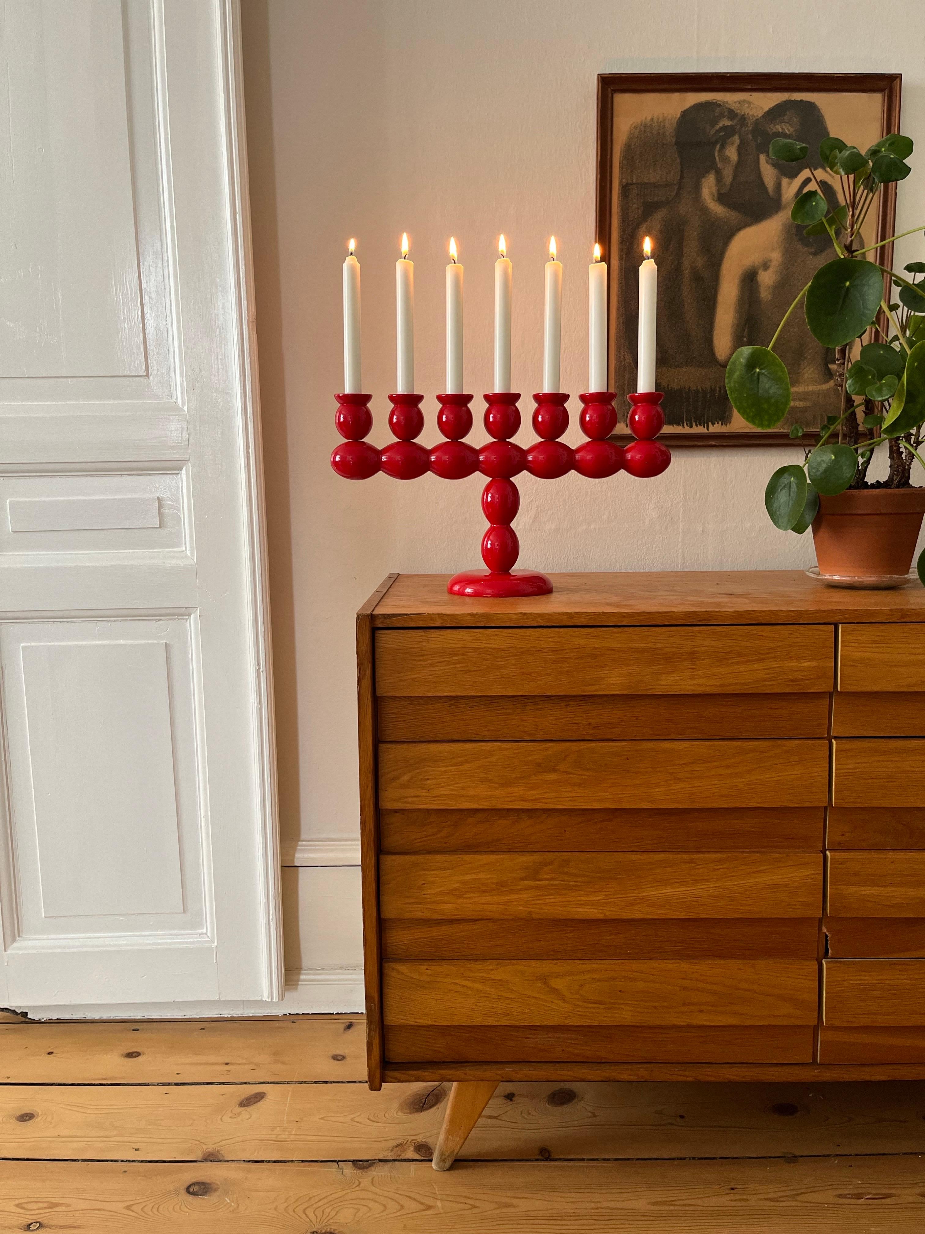 Swedish Red Lacquered Wood Candelabra, 1970s

Seven-arm candelabra in red lacquered wood, Sweden, likely 1970s. The sculptural form is built up of stacked, elongated bobbin-like segments on a round base, suggestive of traditional Scandinavian