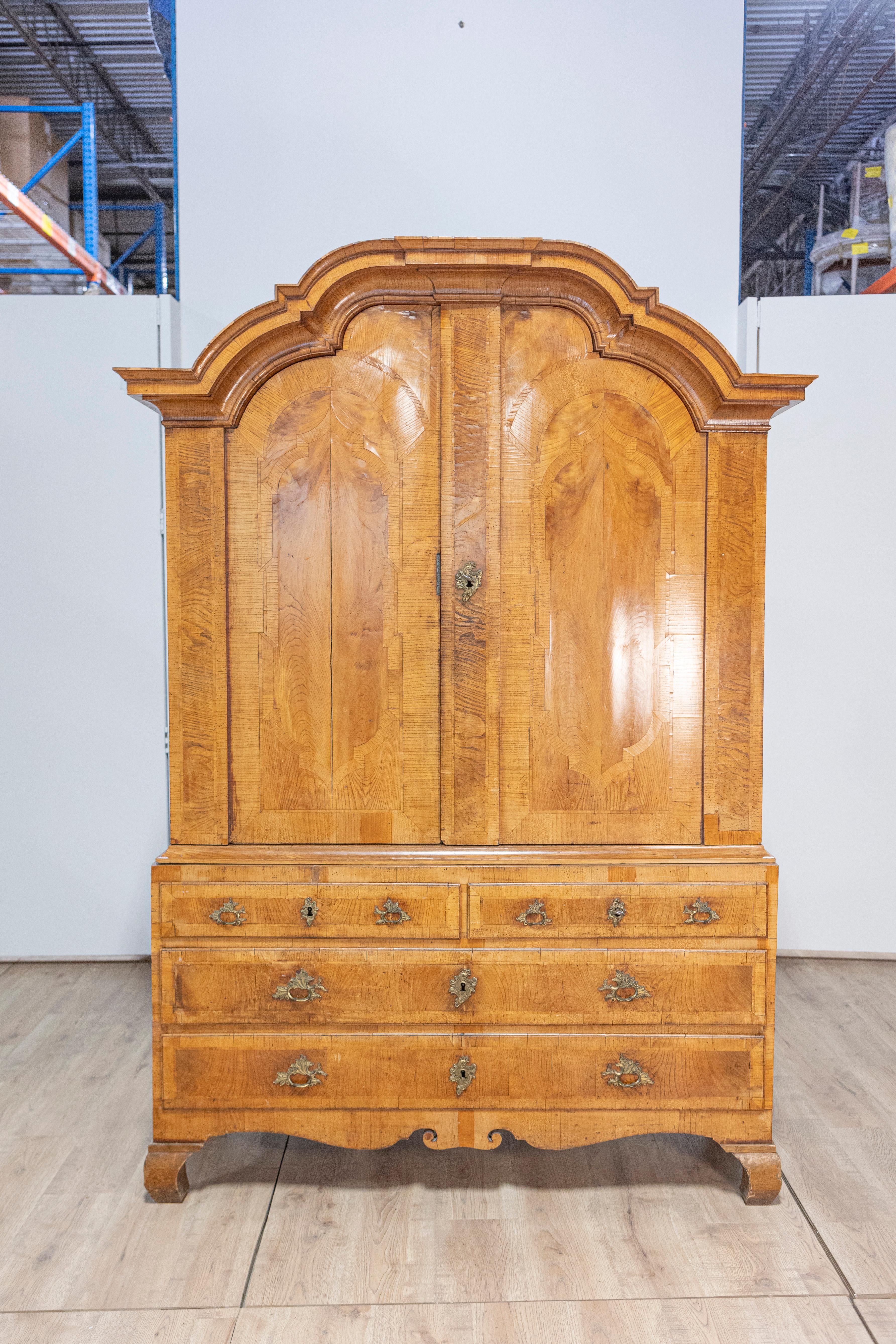 A Swedish Rococo cabinet from circa 1790 with doors and drawers. This exquisite Swedish Rococo cabinet from circa 1790 features a harmonious blend of light European oak and burl walnut. The cabinet's upper section is crowned with a chapeau de