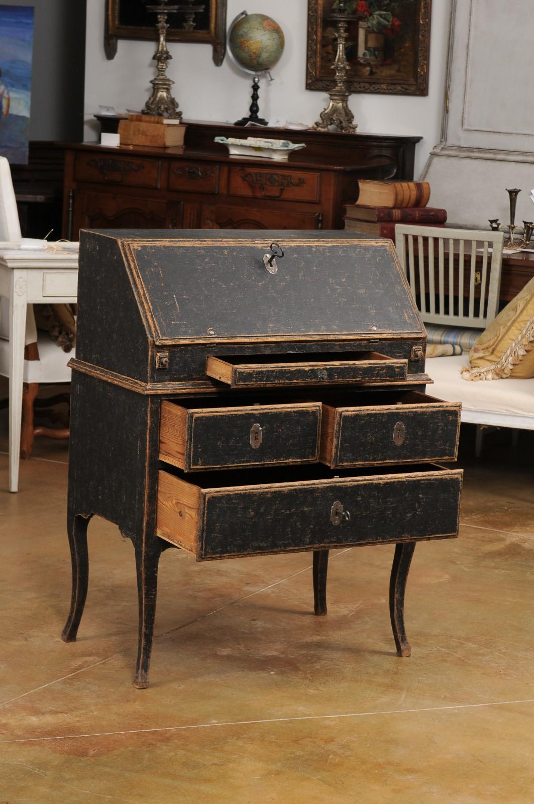 A Swedish Rococo period two-part slant-front desk from the 18th century, repainted in black with a blue interior and later iron hardware. Created in Sweden during the Rococo period, this two-part secretary features a narrow rectangular top sitting