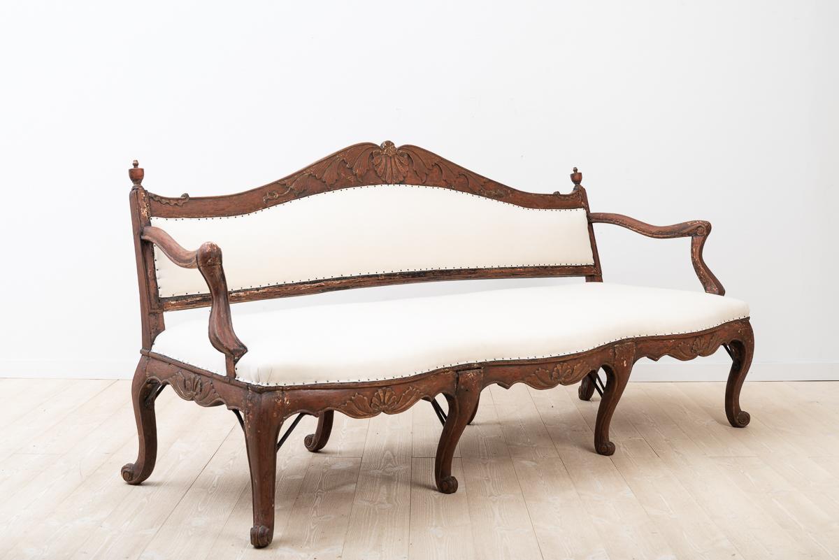 Very rare early rococo sofa from Sweden manufactured around 1760. It has been scraped to the original paint and redressed with a cotton fabric. The legs are reinforced by antique -probably original- hand wrought iron supports.
