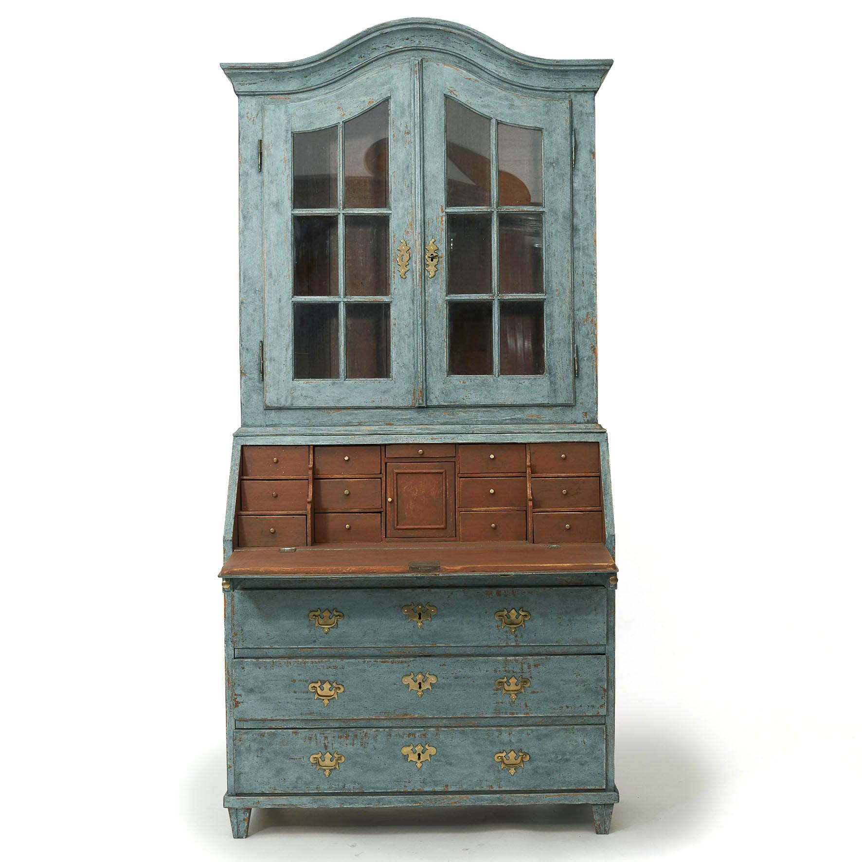 Swedish rococo style bureau in beautiful blue color.
Wall cabinet with a pair of barred glass doors behind which 2 shelves, inside painted in Pompeii red.
Bottom part with sloping writing flap, behind which numerous drawers, painted in Pompeii red