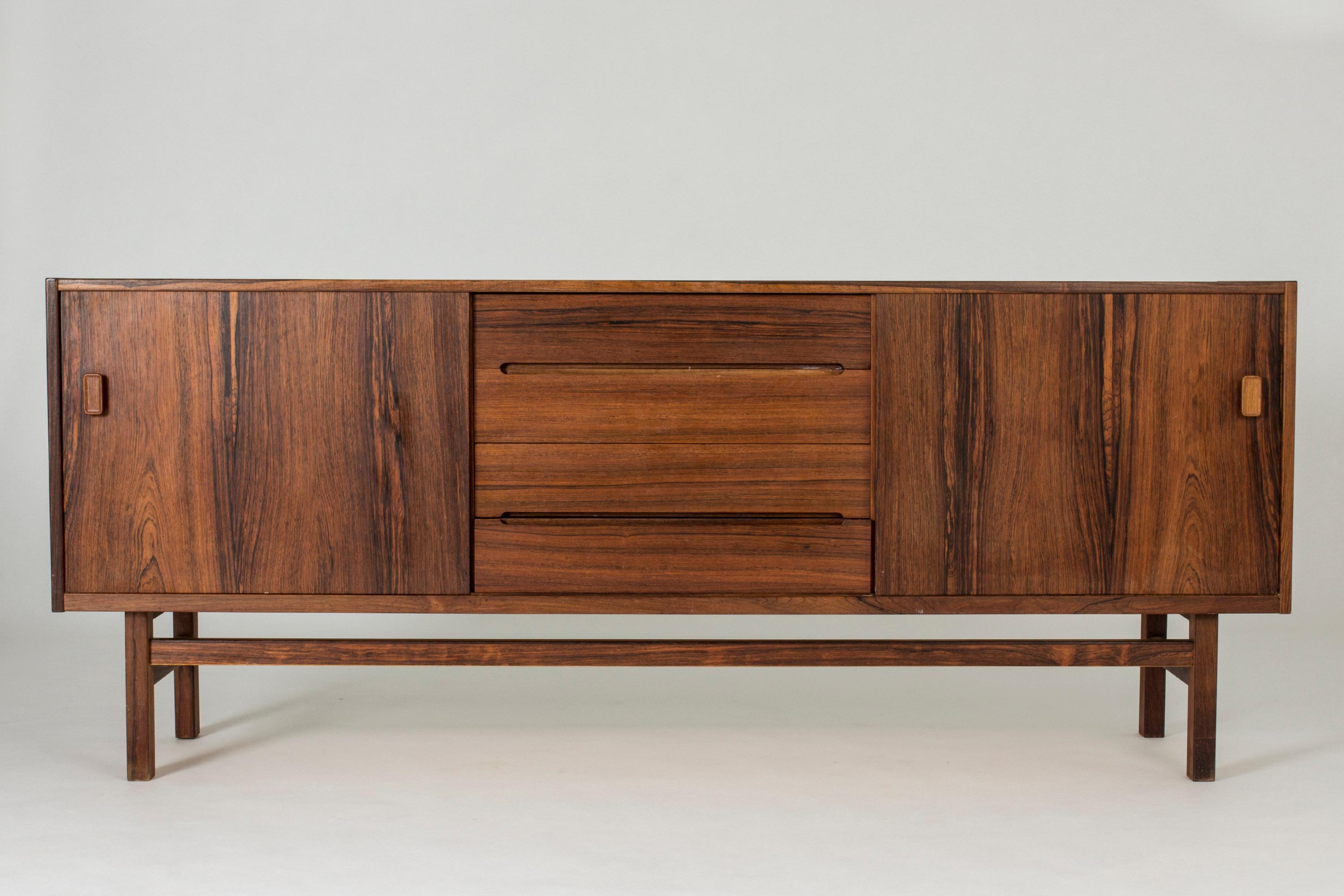 Cool rosewood sideboard by Nils Jonsson. Beautifully sculpted handles in the drawers in the middle and veneer laid in contrasting directions.