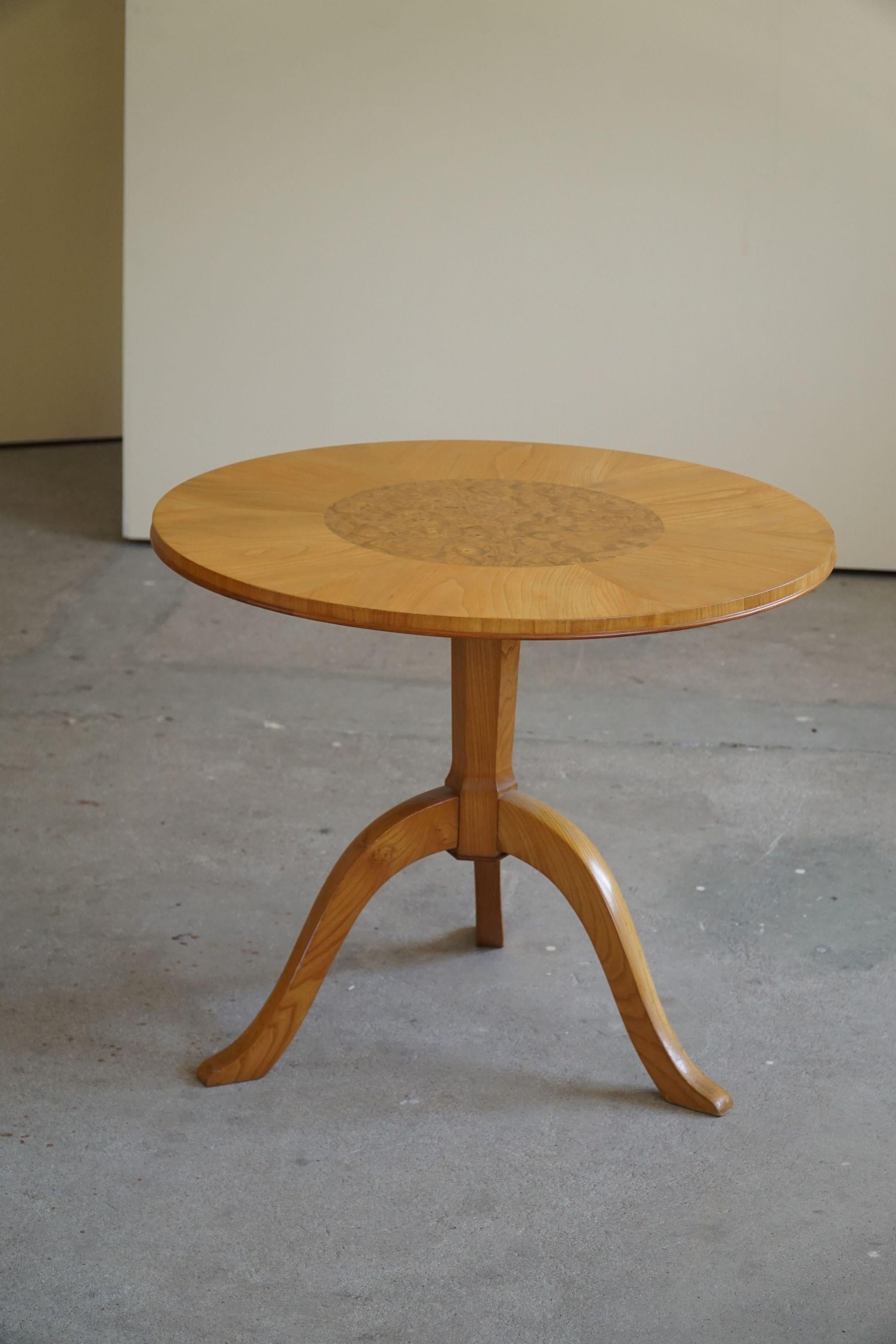 Une table d'appoint ronde classique Art Déco / un piédestal en orme et bouleau. Fabriqué par un ébéniste suédois dans les années 1940.
Design fin et décadent, beau travail de veinage dans cette pièce vintage.
L'impression générale est
