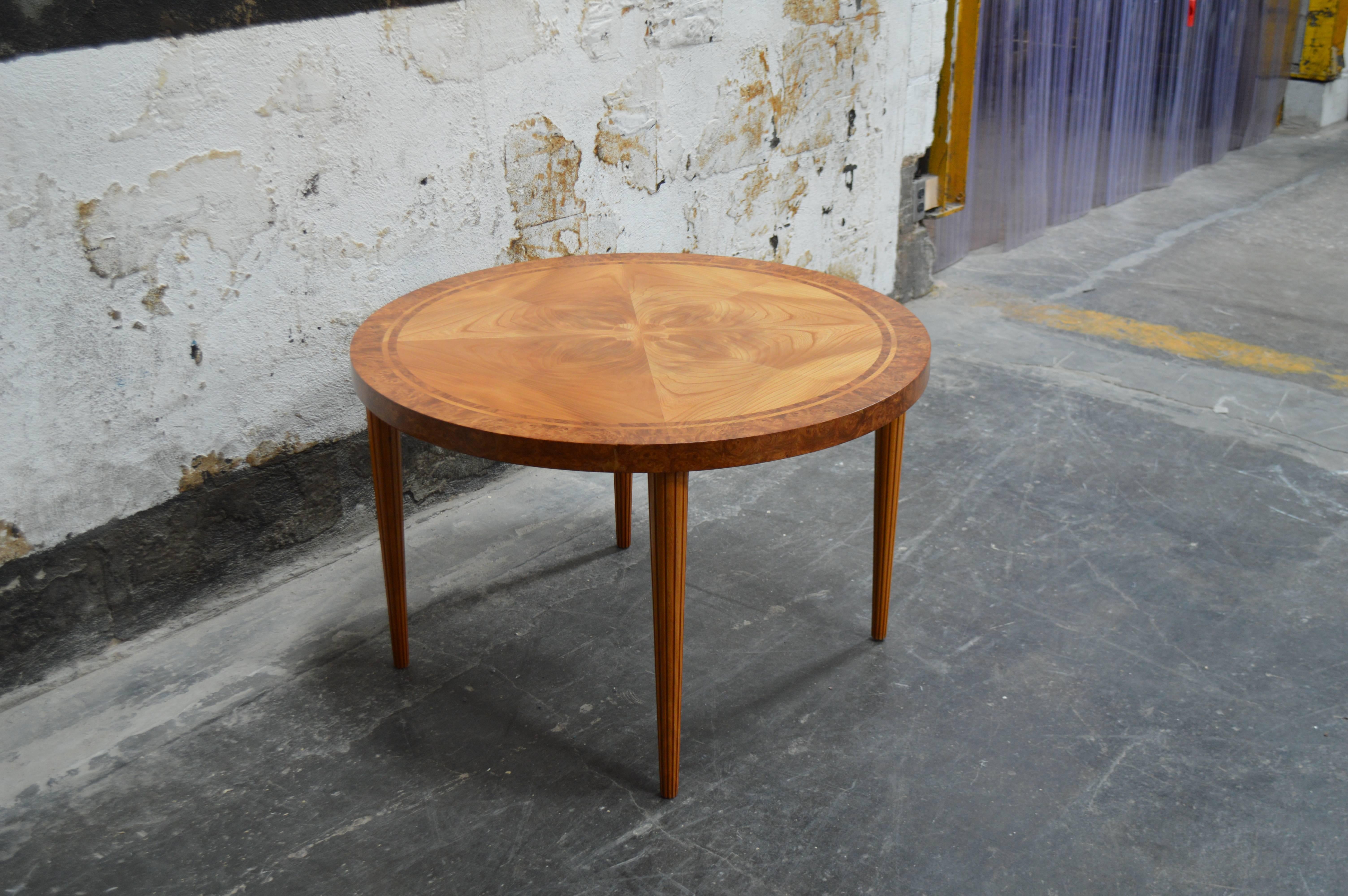 Swedish round golden elm end or side stable. Beautifully detailed with book matched top banded with Carpathian elm for additional interest. Atop tapered reeded legs. A very handsome table and perfectly scaled for any room.