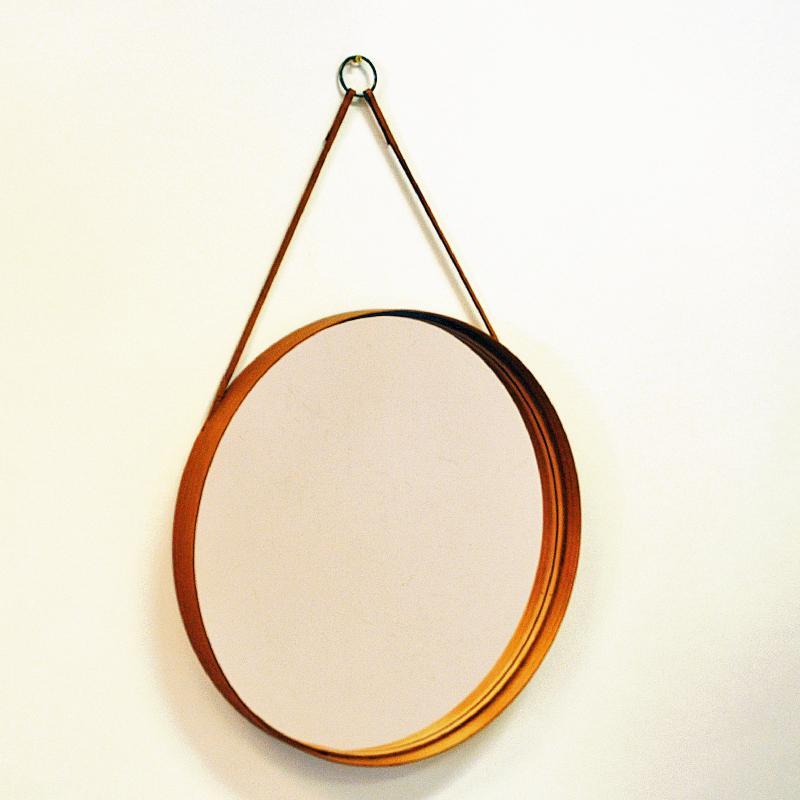 Un beau miroir rond à cadre en teck avec une sangle en cuir pour le suspendre. Bordure intérieure en cuir autour du miroir. Fabriqué par Glasmäster Markaryd:: Suède Années 1960. Il s'intègre parfaitement partout. Dans la cuisine:: la salle de