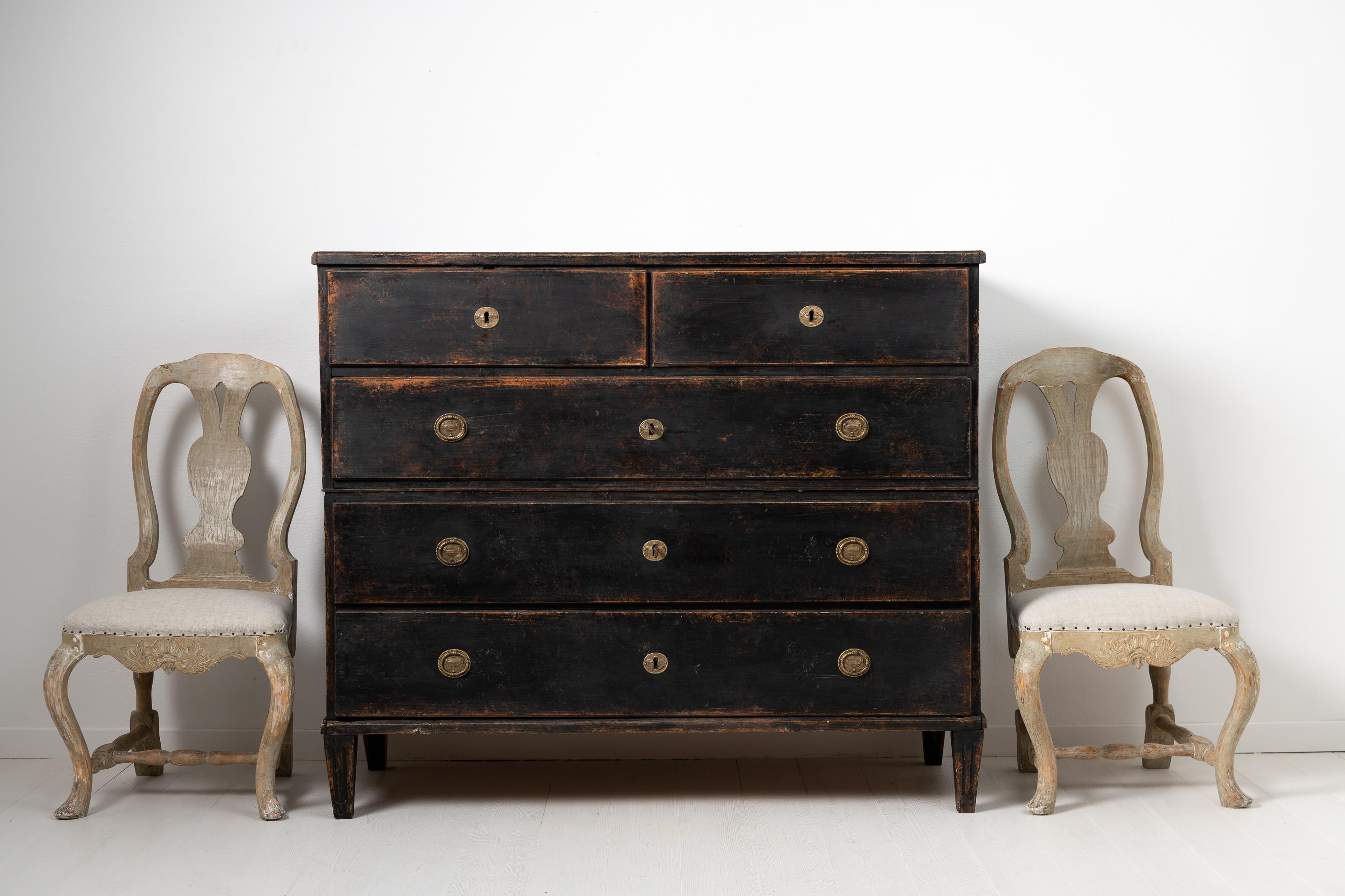 Swedish gustavian chest on chest bureau with black distressed paint from around the year 1800. The bureau is from Stockholm, Sweden and made in painted pine. Made in two parts and with gables with the original handles in wrought iron. The drawers
