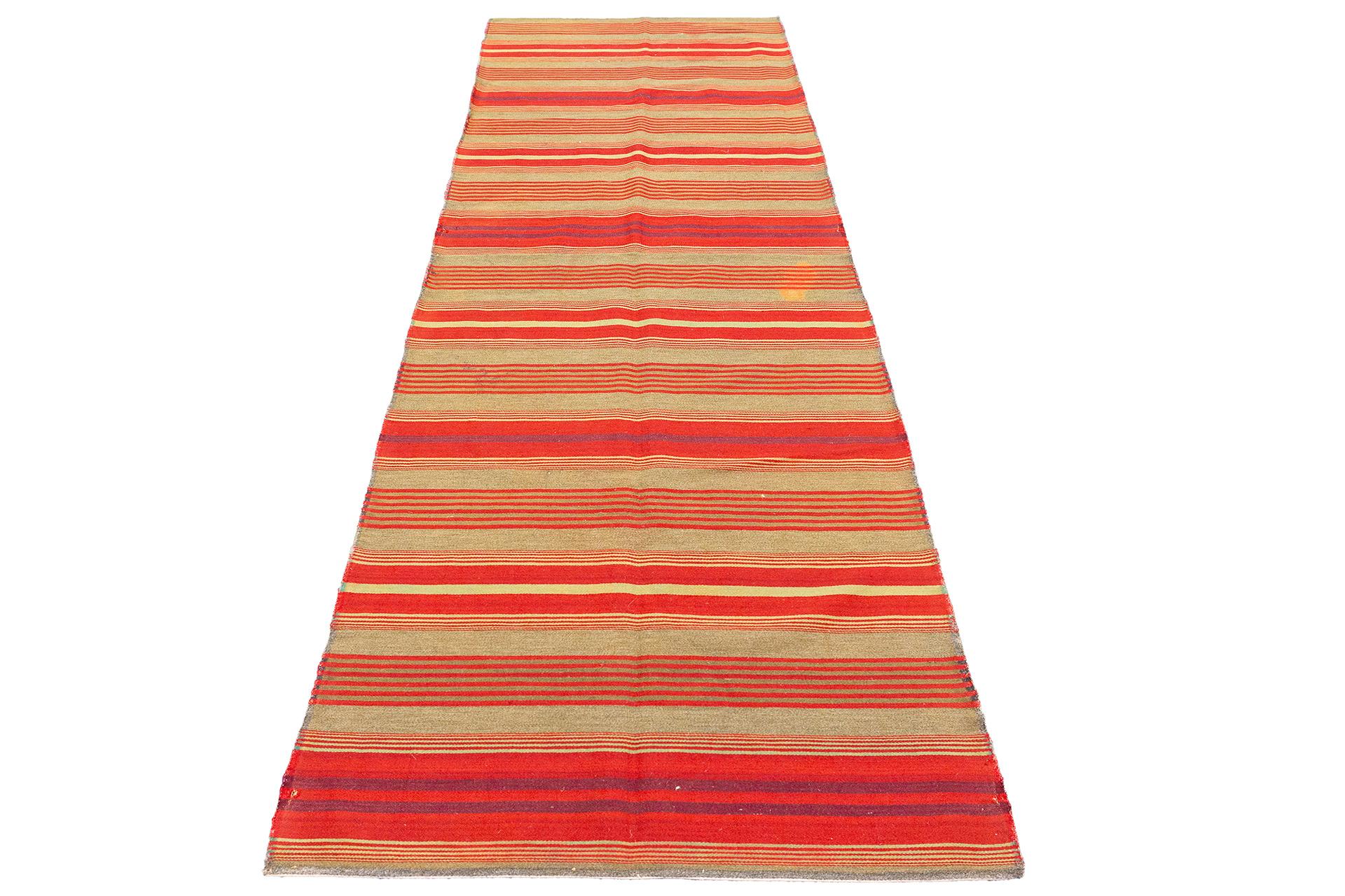 Questo tappeto svedese Kilim Giajim a trama piatta, che misura 66 x 180 cm, presenta un sorprendente design lineare con strisce alternate di colore rosso, arancione e beige scuro. Il motivo pulito e minimalista mette in mostra la tradizionale