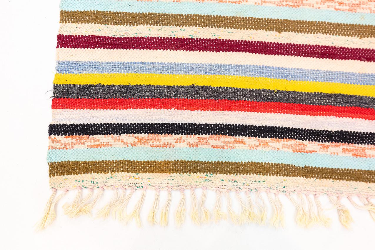 Dieser lebhafte schwedische Teppich in Flachgewebe mit den Maßen 66 x 252 cm ist eine fesselnde Mischung aus Farben und Texturen, die jedem Raum einen lebendigen und raffinierten Touch verleiht. Der Teppich zeichnet sich durch eine harmonische