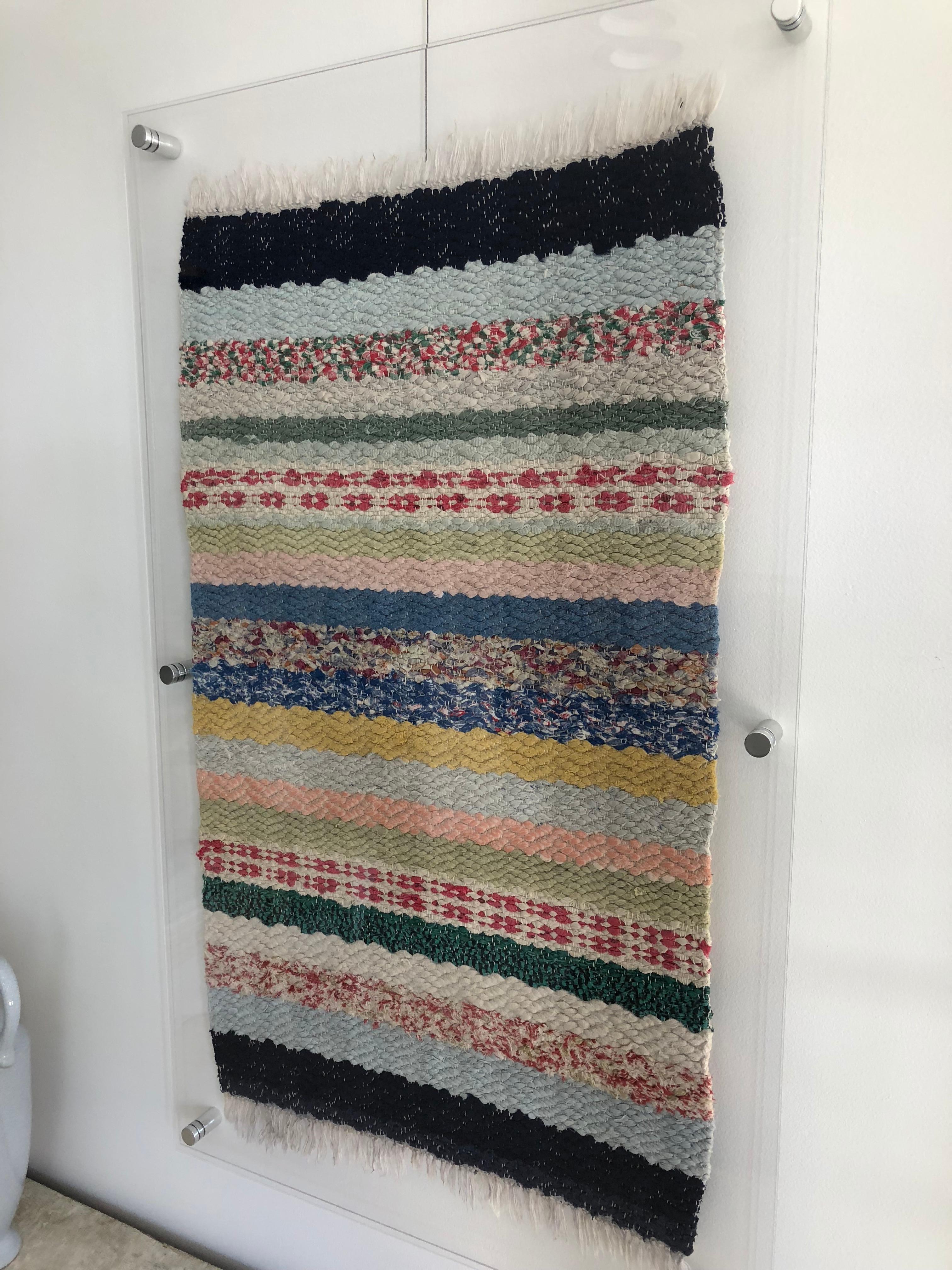 Sweet Swedish Rag Rug Cleverly Framed in Acrylic. Can be hung (wire attached) or bolted to the wall. Lovely texture, colors nicely preserved. Charming in a child room, laundry room or hallway.
