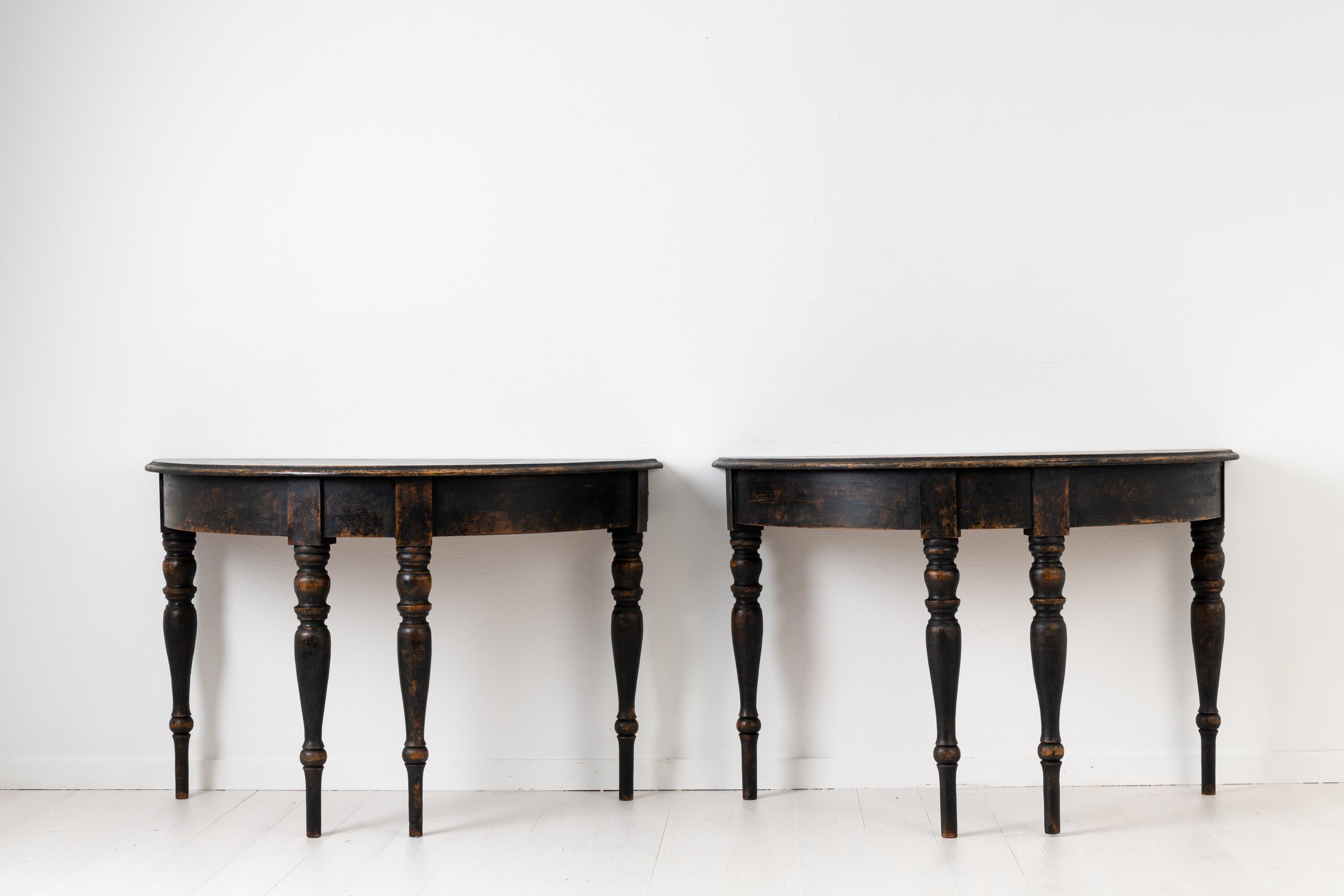 Swedish black demilune tables in Swedish pine. The tables are an original pair and two halves of a whole. They are from Sweden and made circa 1880. The black paint is distressed with some of the wood shining trough the paint and good patina. The