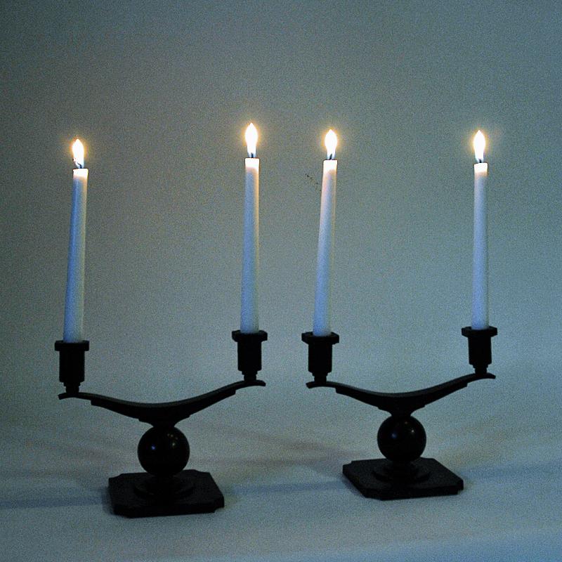 Lovely and rustic set of two bronze candelabras with great patina by Sune Bäckström, Malmö -Sweden 1930s. Arms for two candles balancing on a center bronze ball. The candelabras are nice both with and without candlelights in. Good vintage condition.