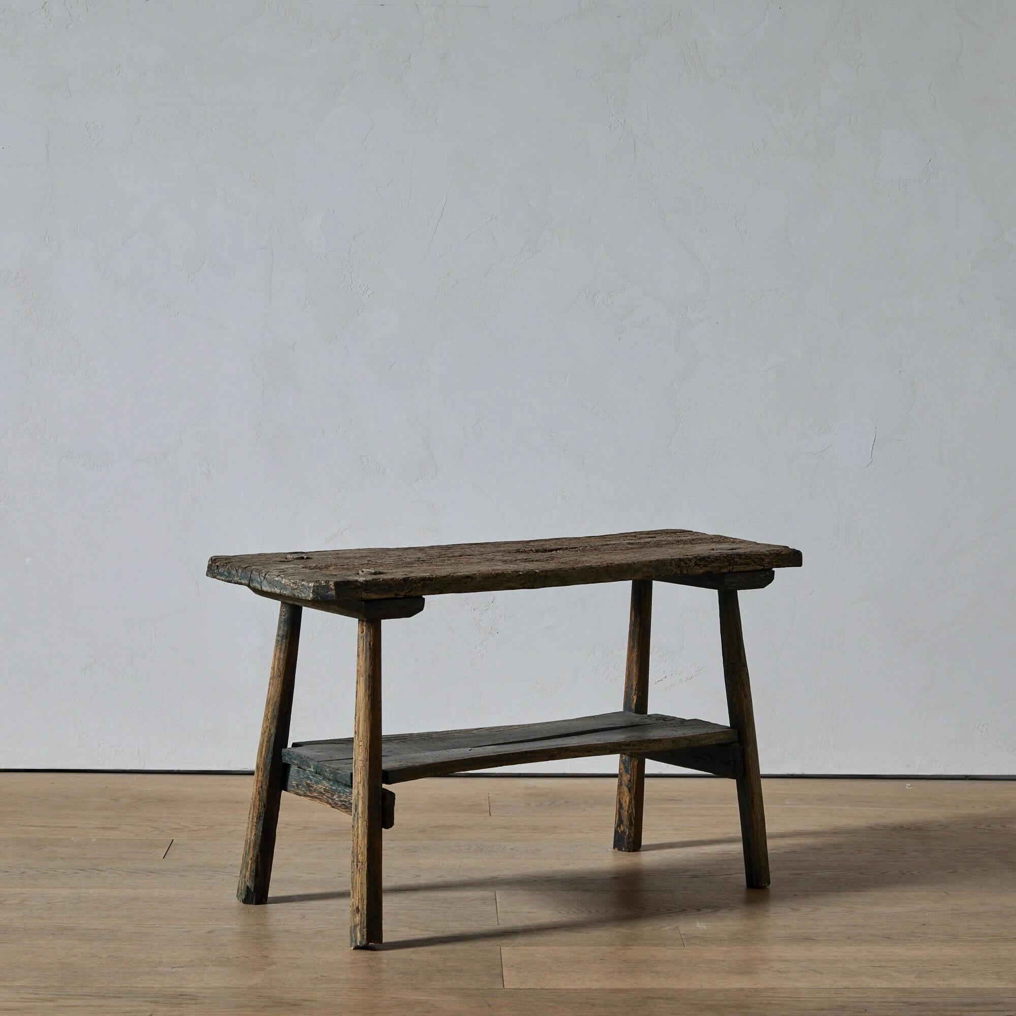 Une étagère rustique à deux niveaux avec une surface joliment usée par le temps et des restes de la peinture bleu-vert d'origine. Ce type de mobilier était fabriqué selon les besoins par un agriculteur ou un ouvrier qualifié avec les matériaux dont