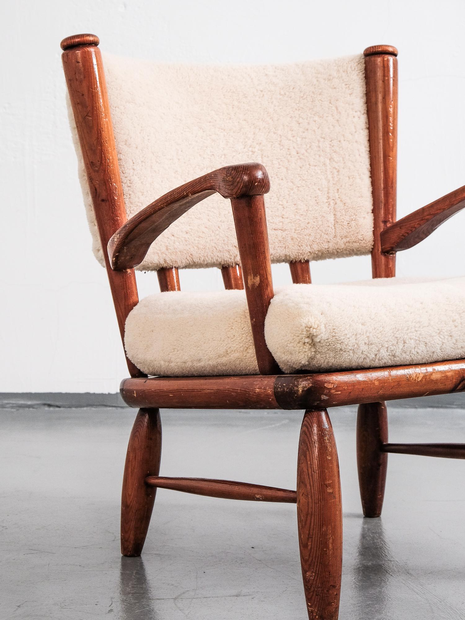 A stout and elegant model 'Säter' lounge chair by Gunnar Göperts from 1940s. Stained pine frame with white teddy fabric upholstery.