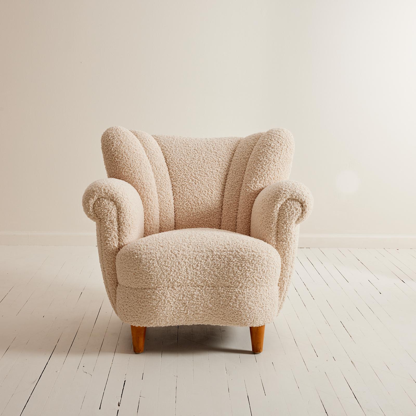 This 1940's Swedish Wingback chair feels both modern and classic at the same time.  The rounded proportions along with the enveloping seat help to create an inviting and comfortable chair.  The newly upholstered fabric is similar to a sheepskin and
