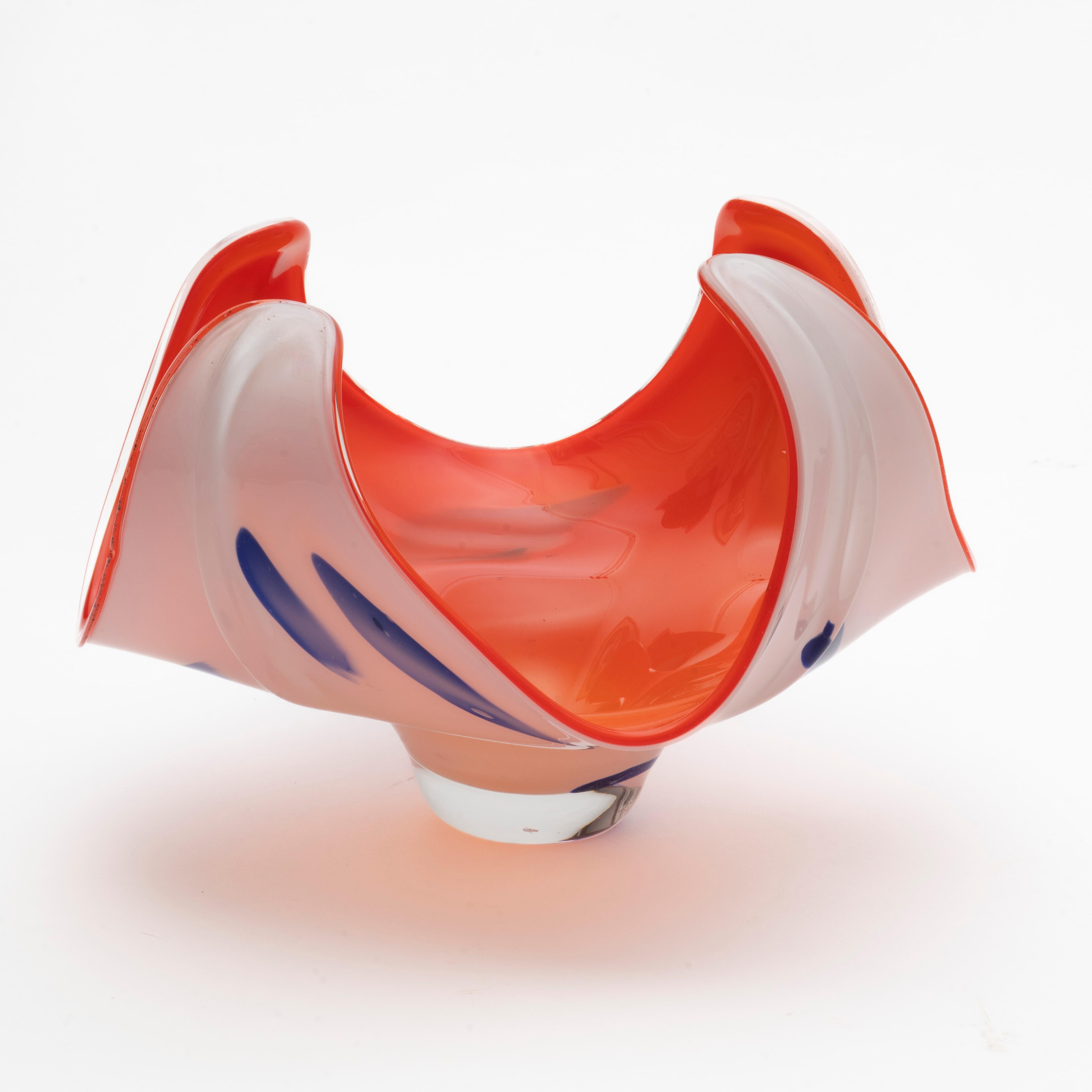 Swedish sculptural glass bowls in the style of Paul Kedelv's artworks for Flygsfors Glasbruk (unsigned).
The glass bowl in the images has the following colors: 
Orange: The inside of the bowl is a vibrant orange color.
White: The outer layer of the