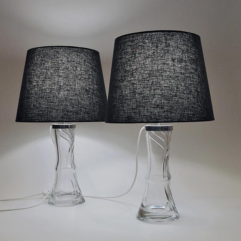 Lovely grooved glass table lamp pair model 2193 designed by Olle Alberius for the Swedish glasswork company Orrefors in the 1960s. These lamps are made of clear glass with a twirly look and an elegante shape and design. Gives a lovely shine when