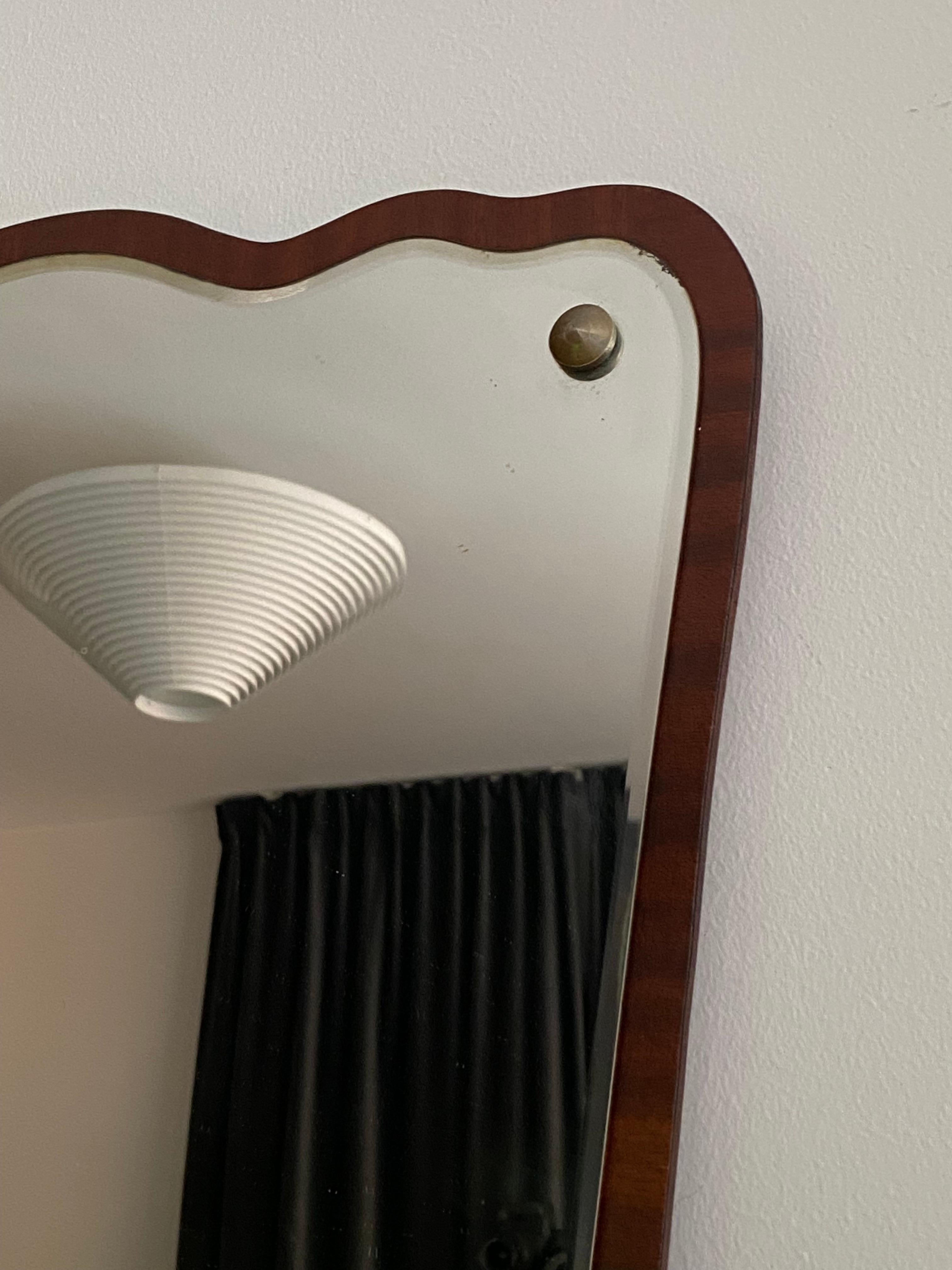 An organic wall mirror, Sweden. In sculpted teak and crystal mirror glass. 

Other designers of the period working in the organic style include Fontana Arte, Gio Ponti, and Paolo Buffa.