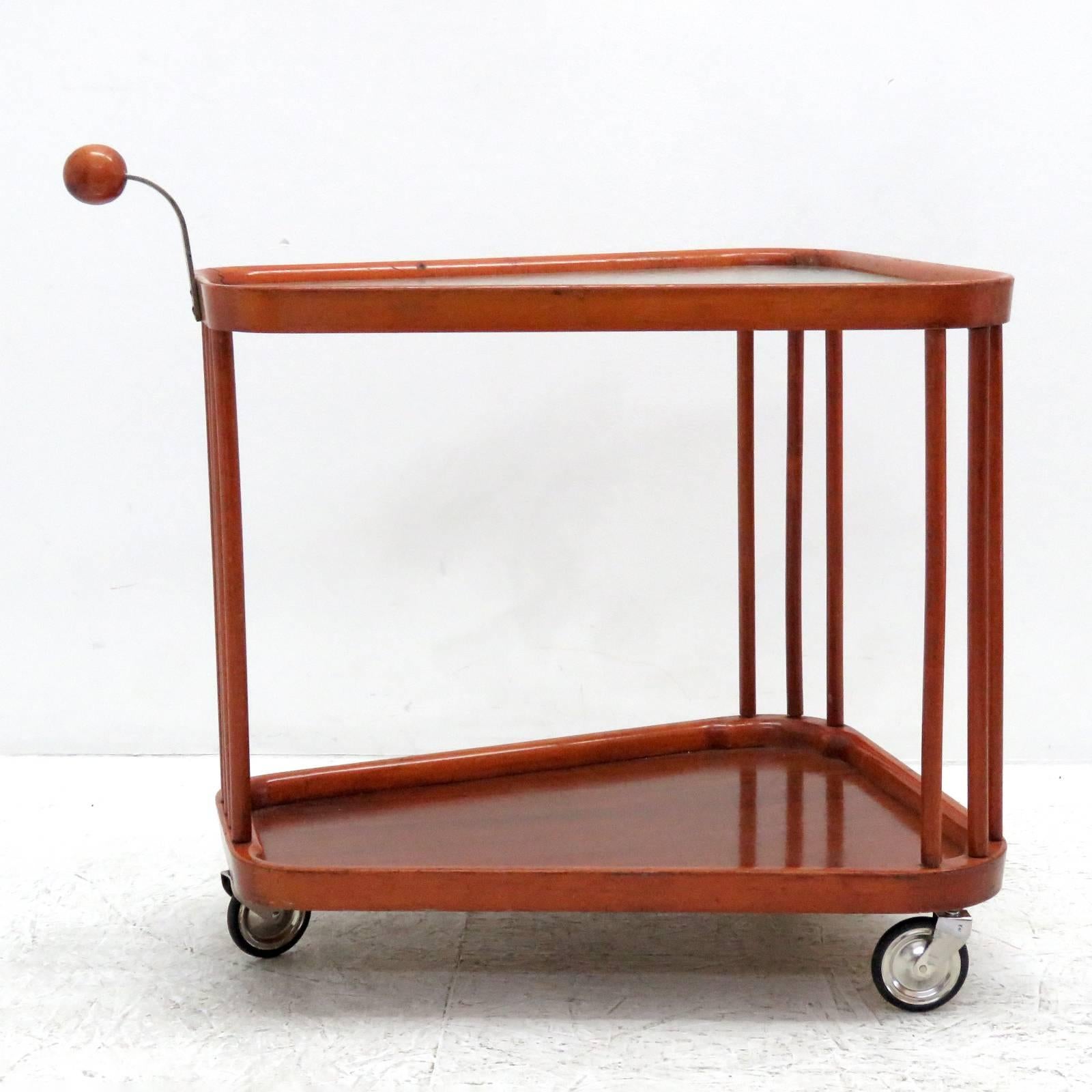 Sculptural two-tier wooden serving cart with textured glass top on three metal casters from Sweden, 1960s, with wooden spherical handle.