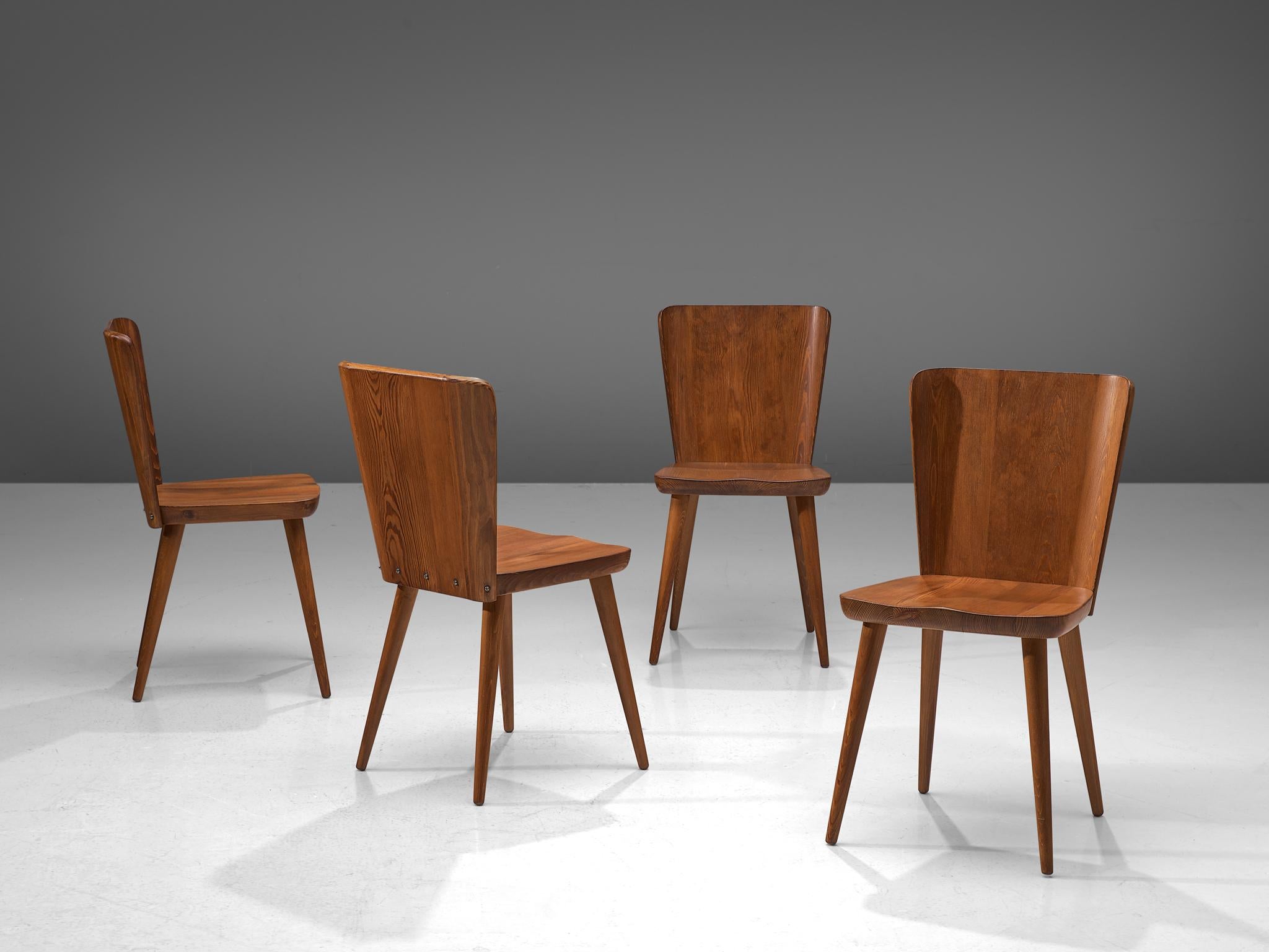 Goran Malmvall for Svensk Fur, set of 4 chairs, pine, Sweden, 1940s. 

This Swedish set of dining chairs holds a strong expression with this sturdy shaped design. The backrests runs wide near the top and consists of straight and slightly curved