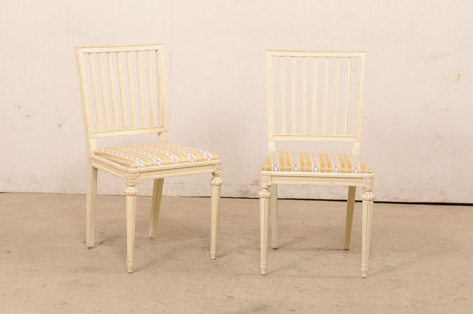 A Swedish set of six side chairs, with their original finish, from the mid 20th century. This vintage set of chairs from Sweden each have squared open slat-backs, upholstered seats, and cleanly designed seat rails with delicate petite bead trimming