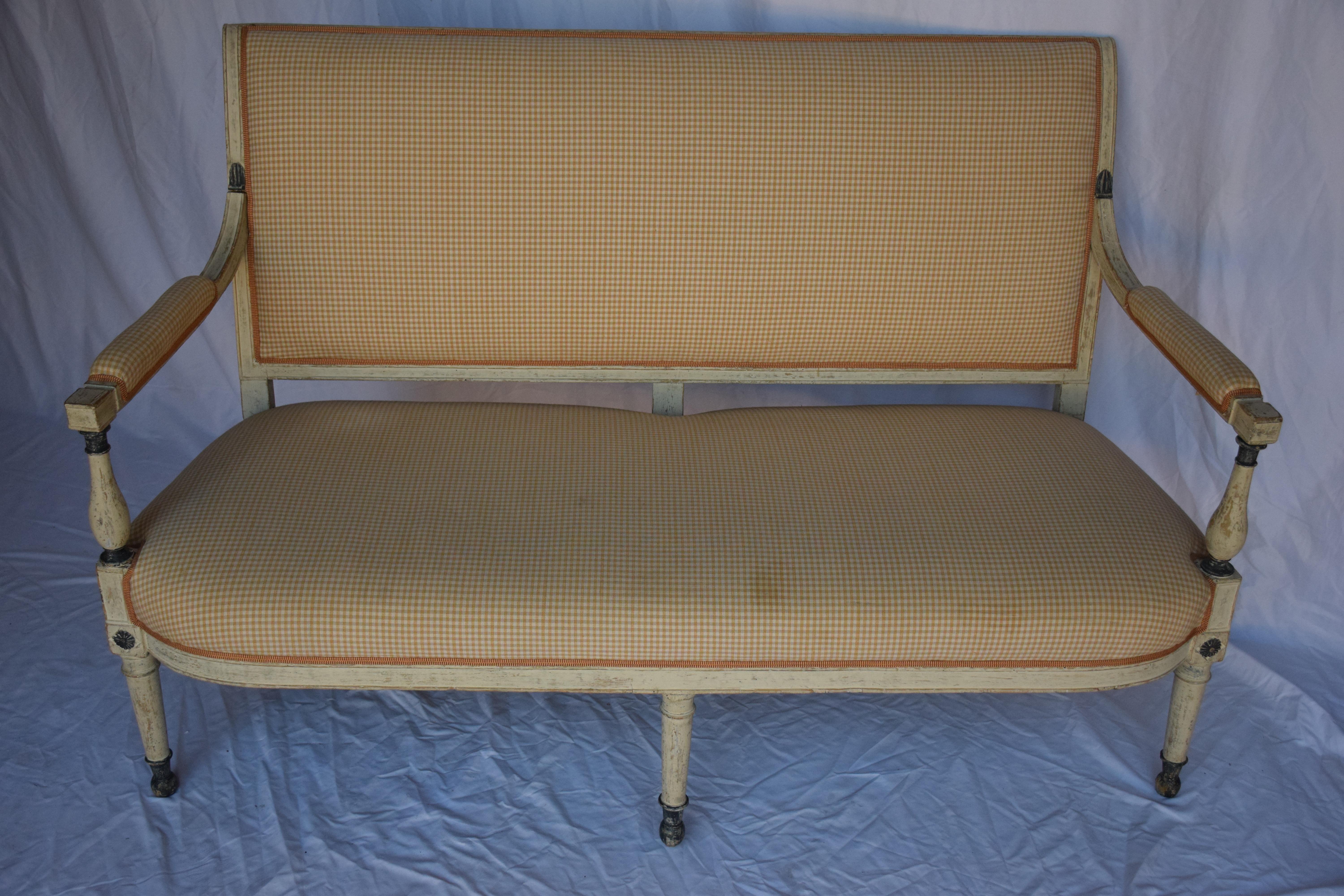 A beautiful Swedish settee suitable for bedrooms and living areas. The sofa frame is adorned with gilt accents on shaped legs with brass caps and currently upholstered in a cotton fabric with a trim accent. 