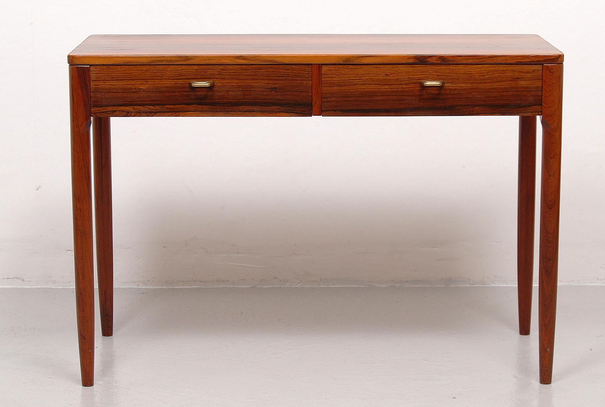 Small side cabinet in rosewood with two drawers and handles in brass. tabletop shows some signs from previous restoration.
 