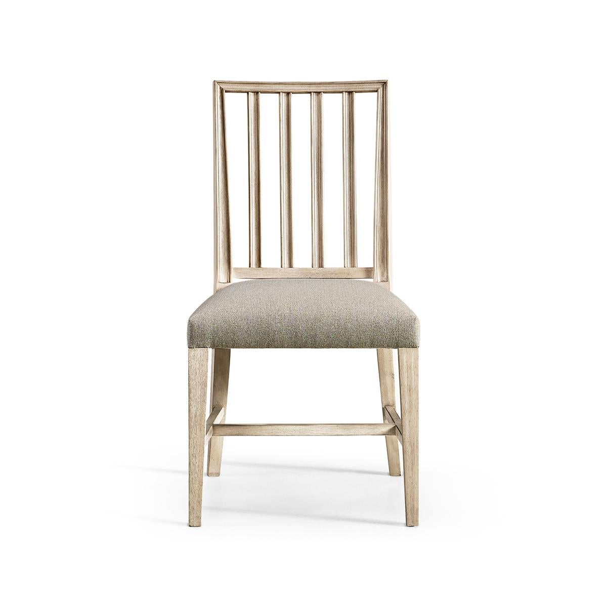 Swedish side chair in a bleached walnut finish, with pristine forms and clean lines capable of dressing a dining space up or down with ease. With a molded slat back and a delightfully plush cushion upholstered in a creamy oatmeal performance fabric