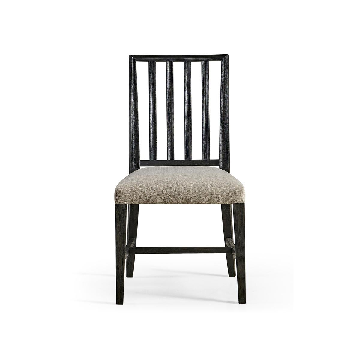 Swedish side chair in an ebonized finish, with pristine forms and clean lines capable of dressing a dining space up or down with ease. With a molded slat back and a delightfully plush cushion upholstered in a creamy oatmeal performance fabric for