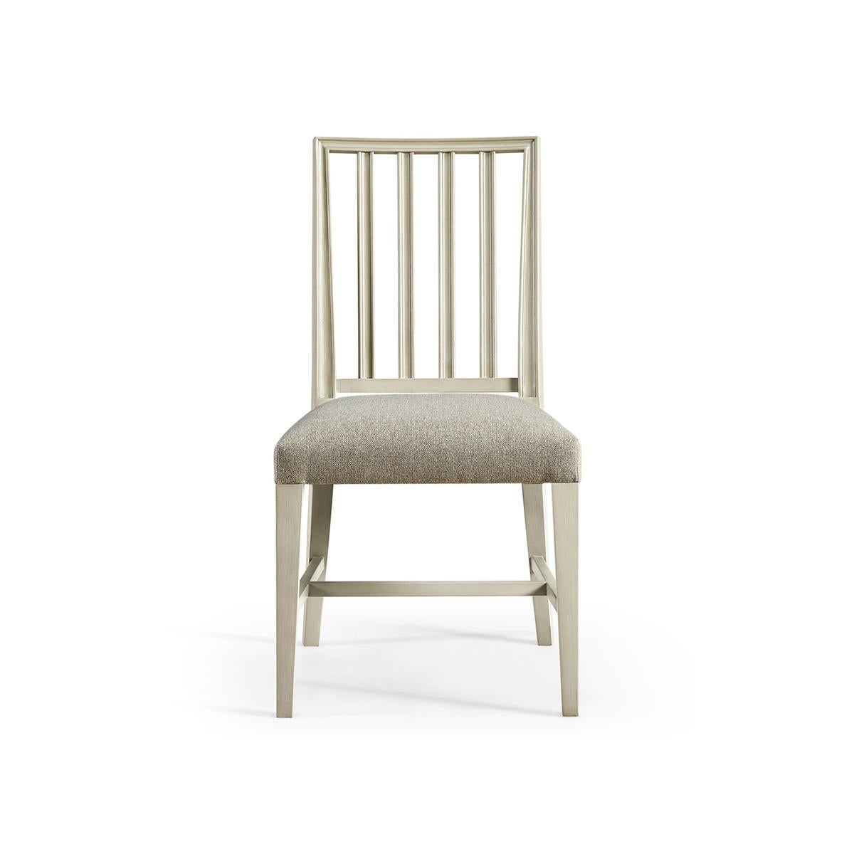 Swedish side chair in light London mist finish, with pristine forms and clean lines capable of dressing a dining space up or down with ease. With a molded slat back and a delightfully plush cushion upholstered in a creamy oatmeal performance fabric