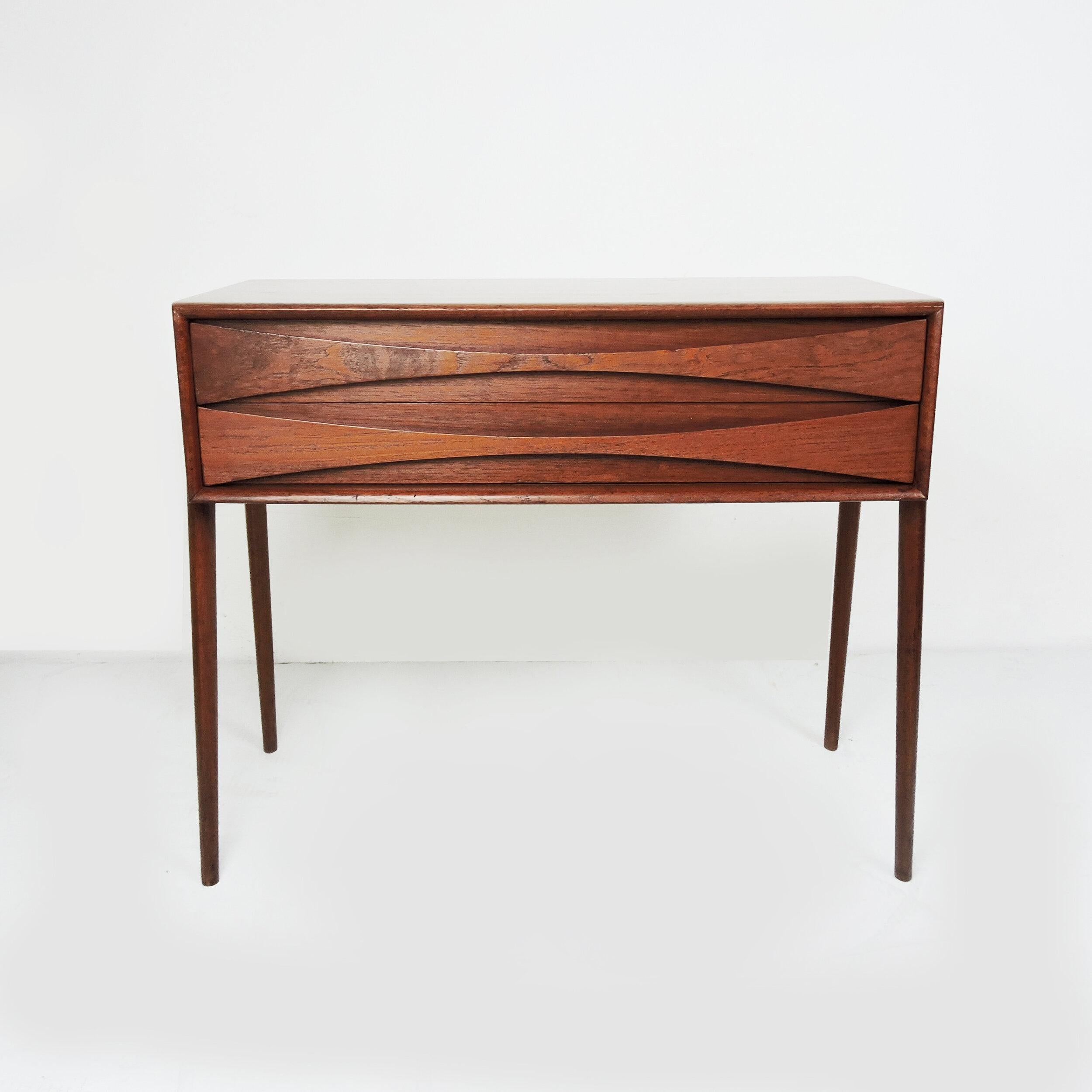 A teak side table by Rimbert Sandholt for Glas & Trä Hovmantorp. It features two decorative drawers with shaped legs.

Designer - Rimbert Sandholt

Manufacturer - Glas & Trä Hovmantorp

Design Period - 1960 to 1969

Country of Manufacture -