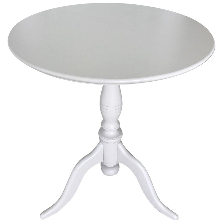 Based on Classic 19th century antique guéridon tables from Sweden featuring a round shaped tilt-top. This Gustavian style side table is hand painted in Classic gray / taupe finish. Elegant tilt-top over a turned wood pedestal base with hand carved