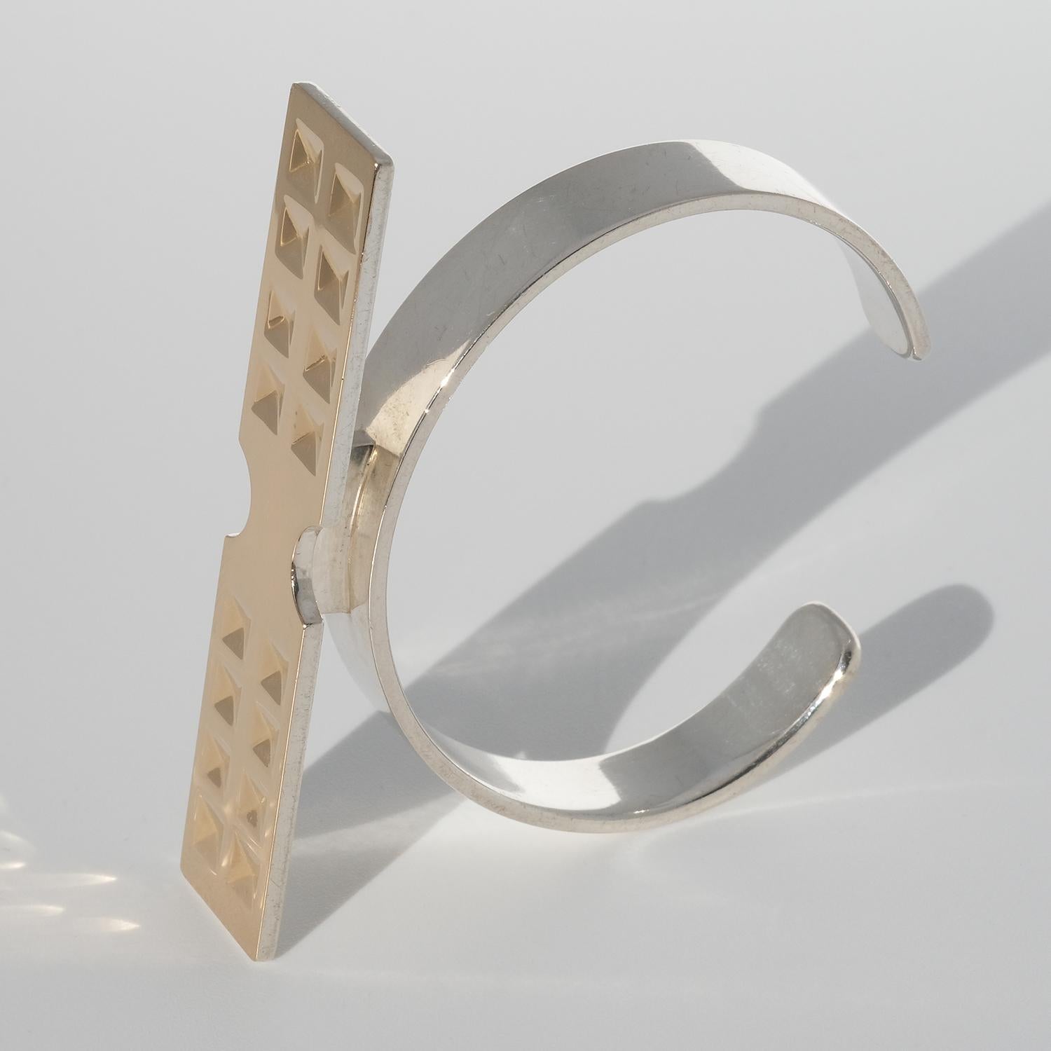 This sterling silver cuff bracelet has gold on its upper part. The fixed cuff bracelet is excellent with its firm, waffled adornment and geometrically curved arms. This bracelet sums up all the fabulous things about the eighties.

The cuff bracelet