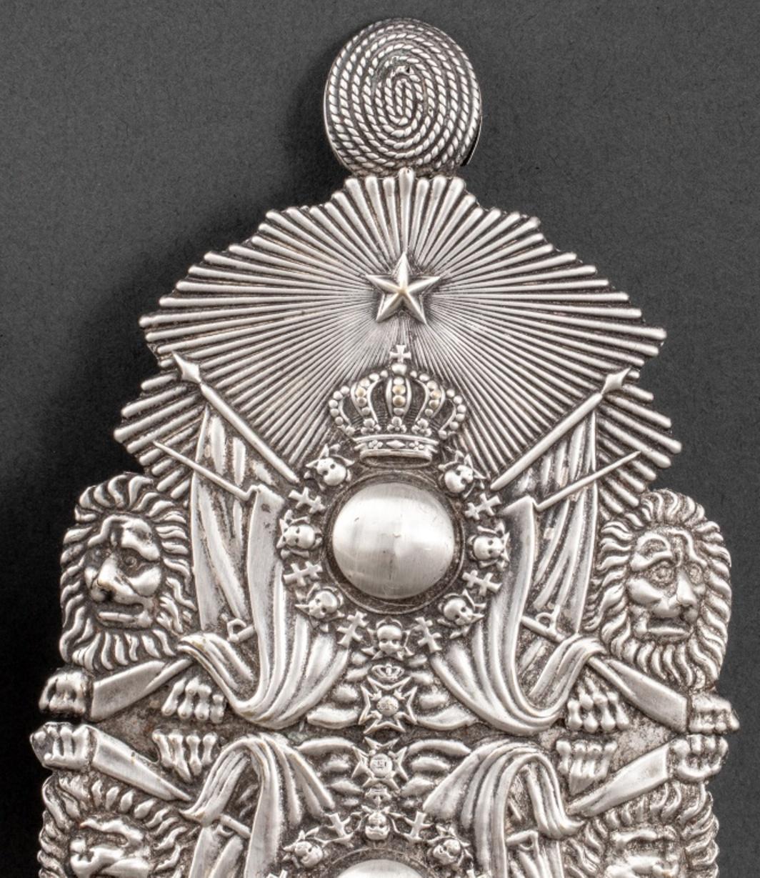 Pair of Swedish silver plated one light reflector sconces, made from Swedish Royal Guards' helmet mounts and depicting the royal crown and collar of the Swedish Order of the Seraphim.

Dimensions: 11
